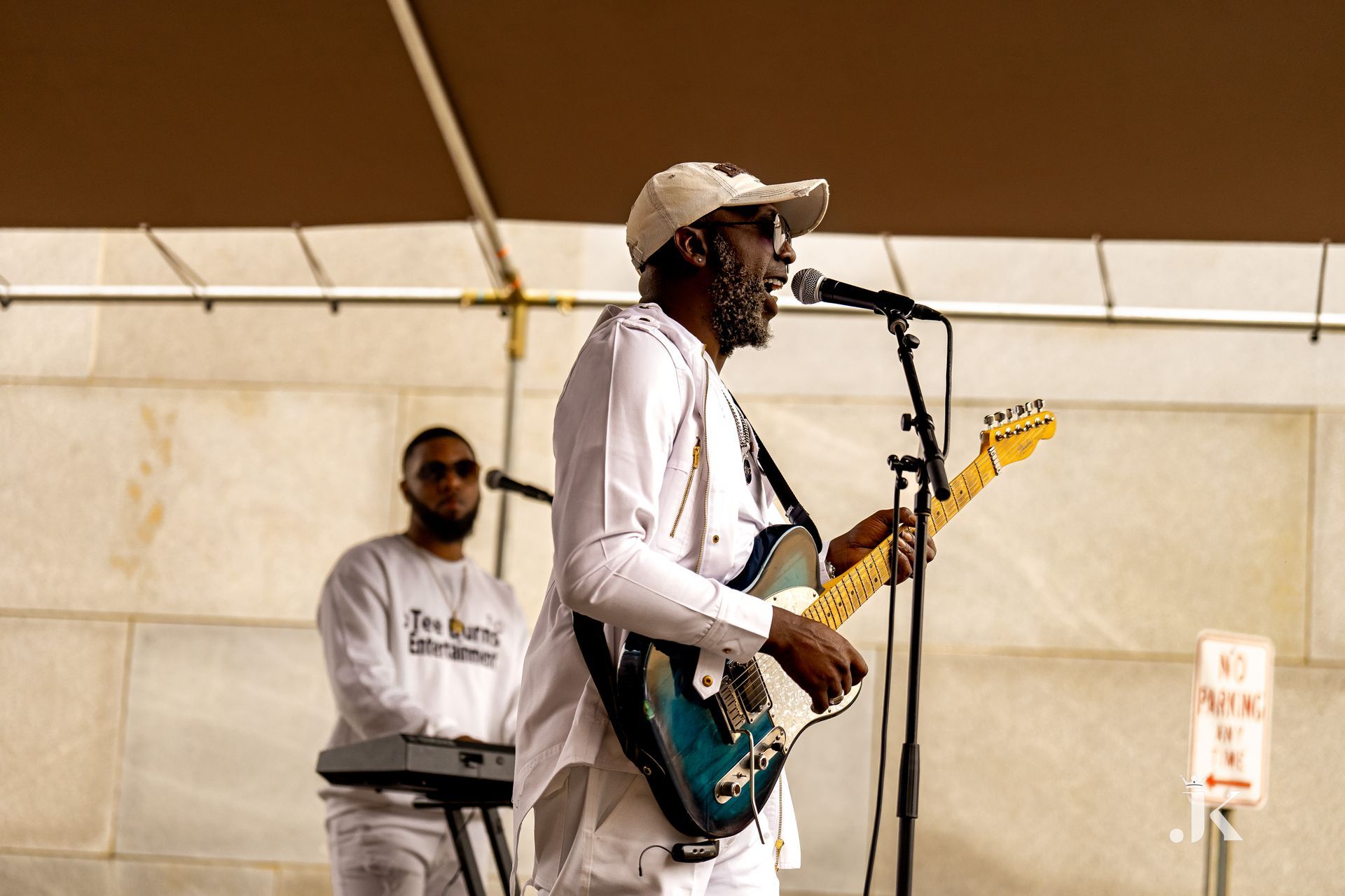 A man is singing into a microphone while playing a guitar.