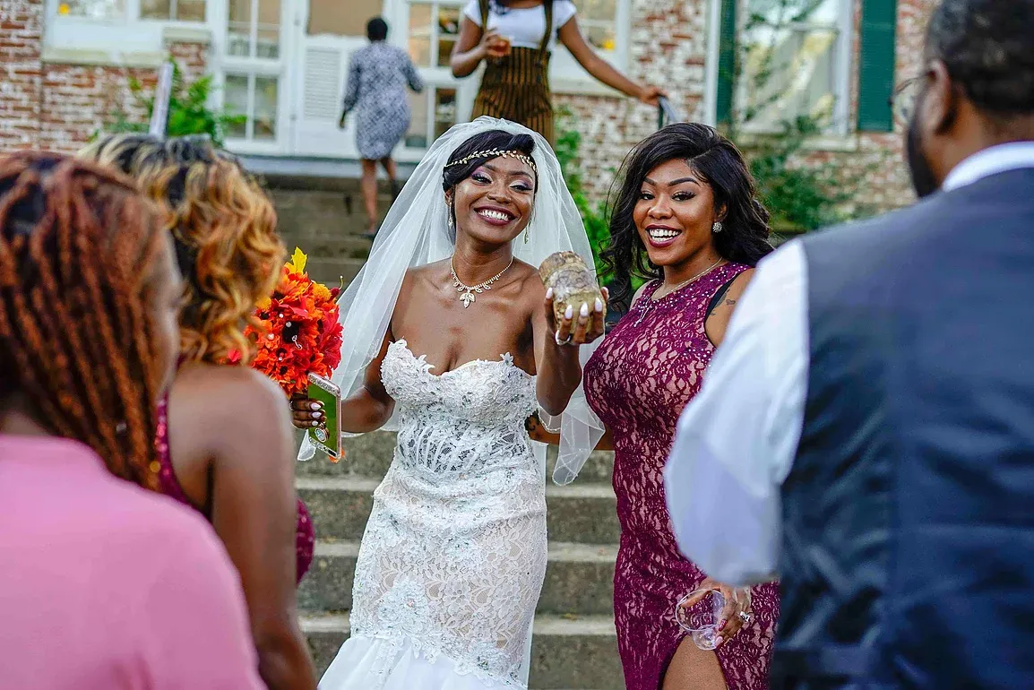 A bride in a wedding dress is standing in front of a group of people.