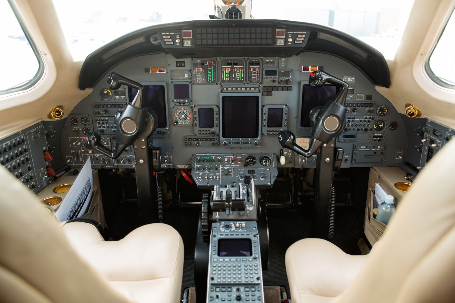 A cockpit of an airplane with two seats and a steering wheel.