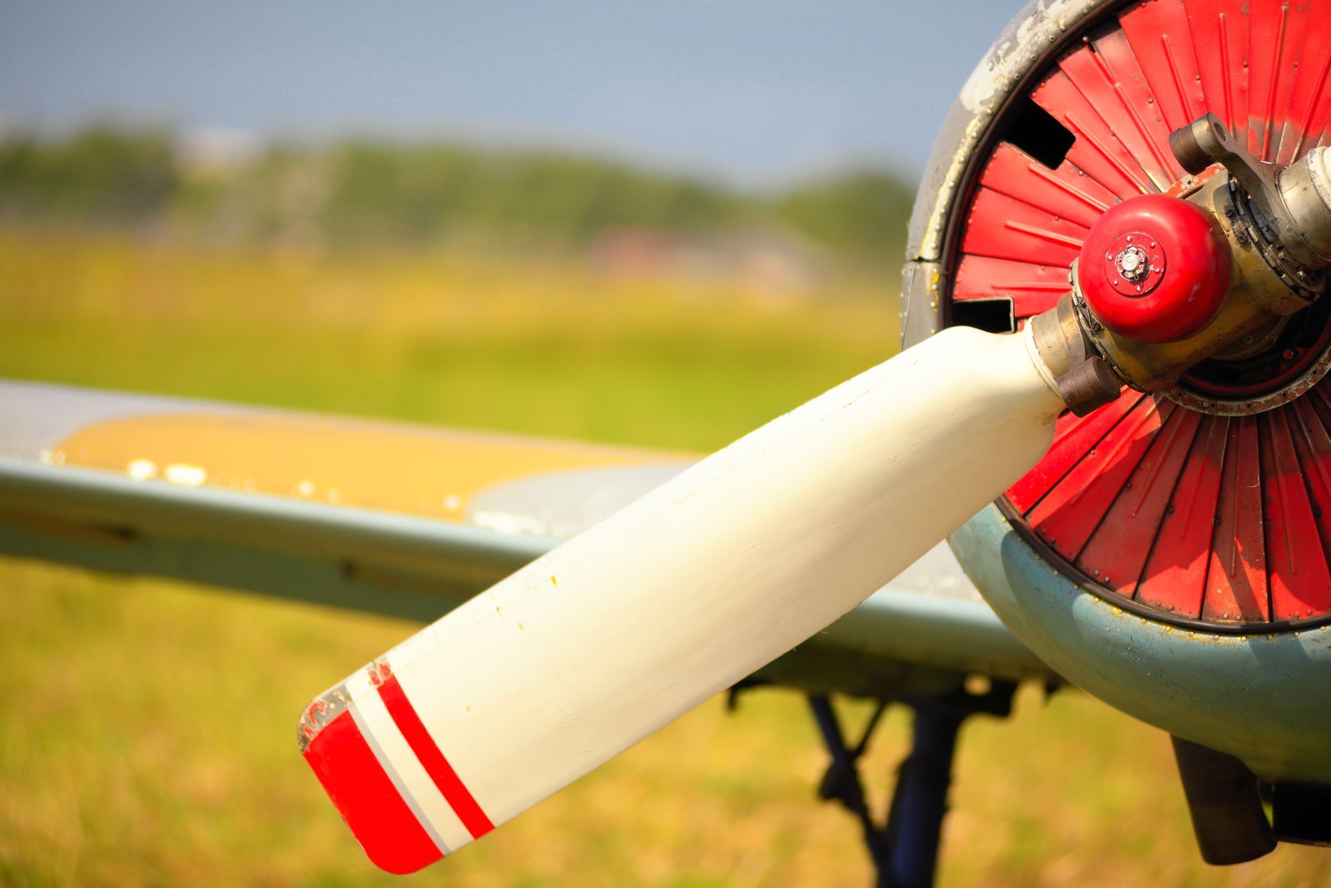 A close up of a propeller of an airplane in a field.