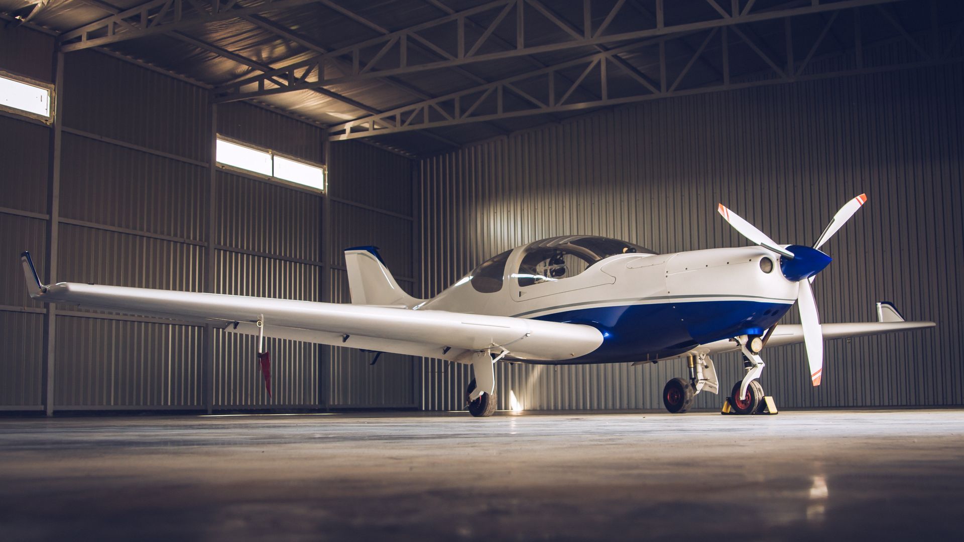 A small propeller plane is parked in a hangar.