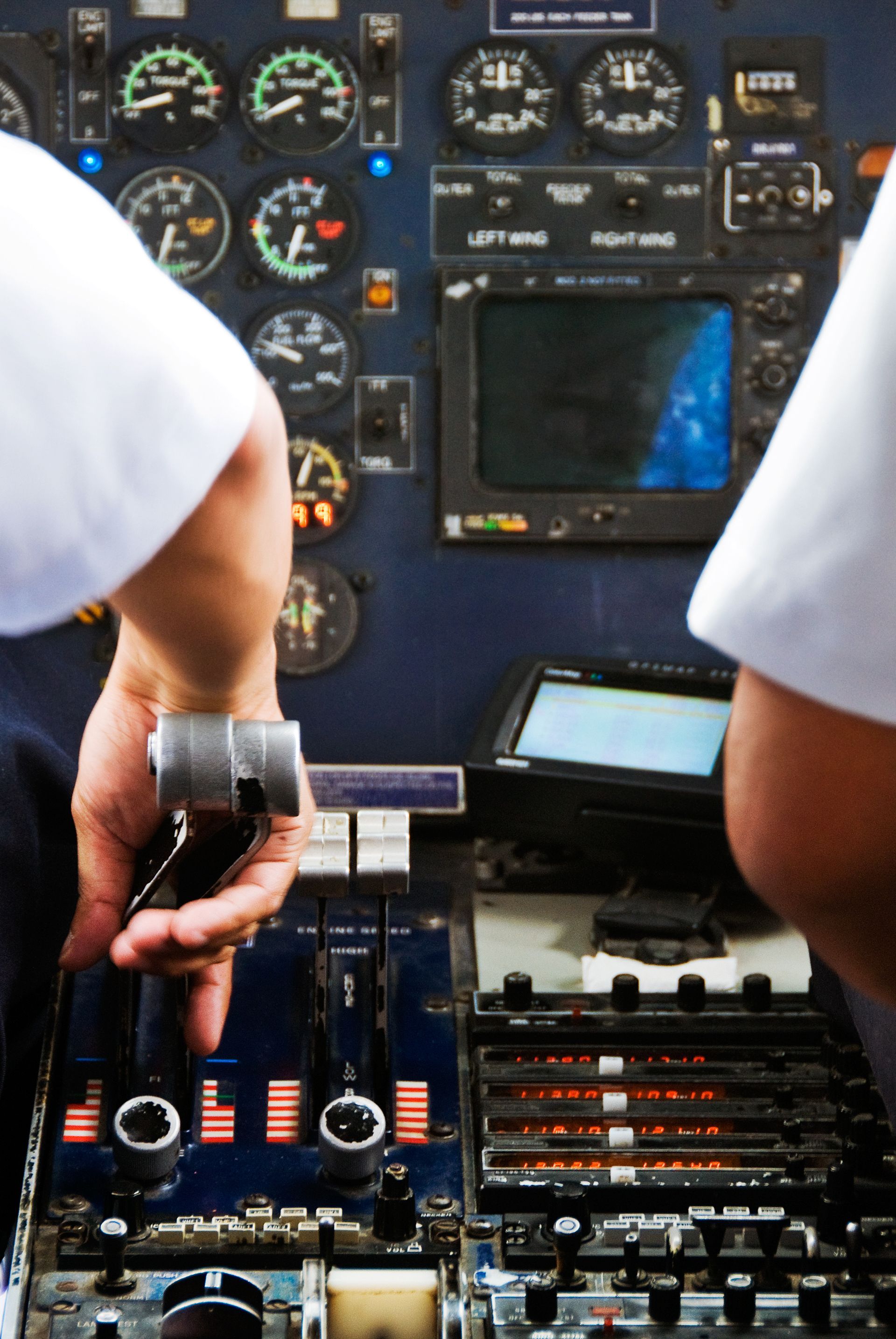 A pilot is holding a steering wheel in a cockpit