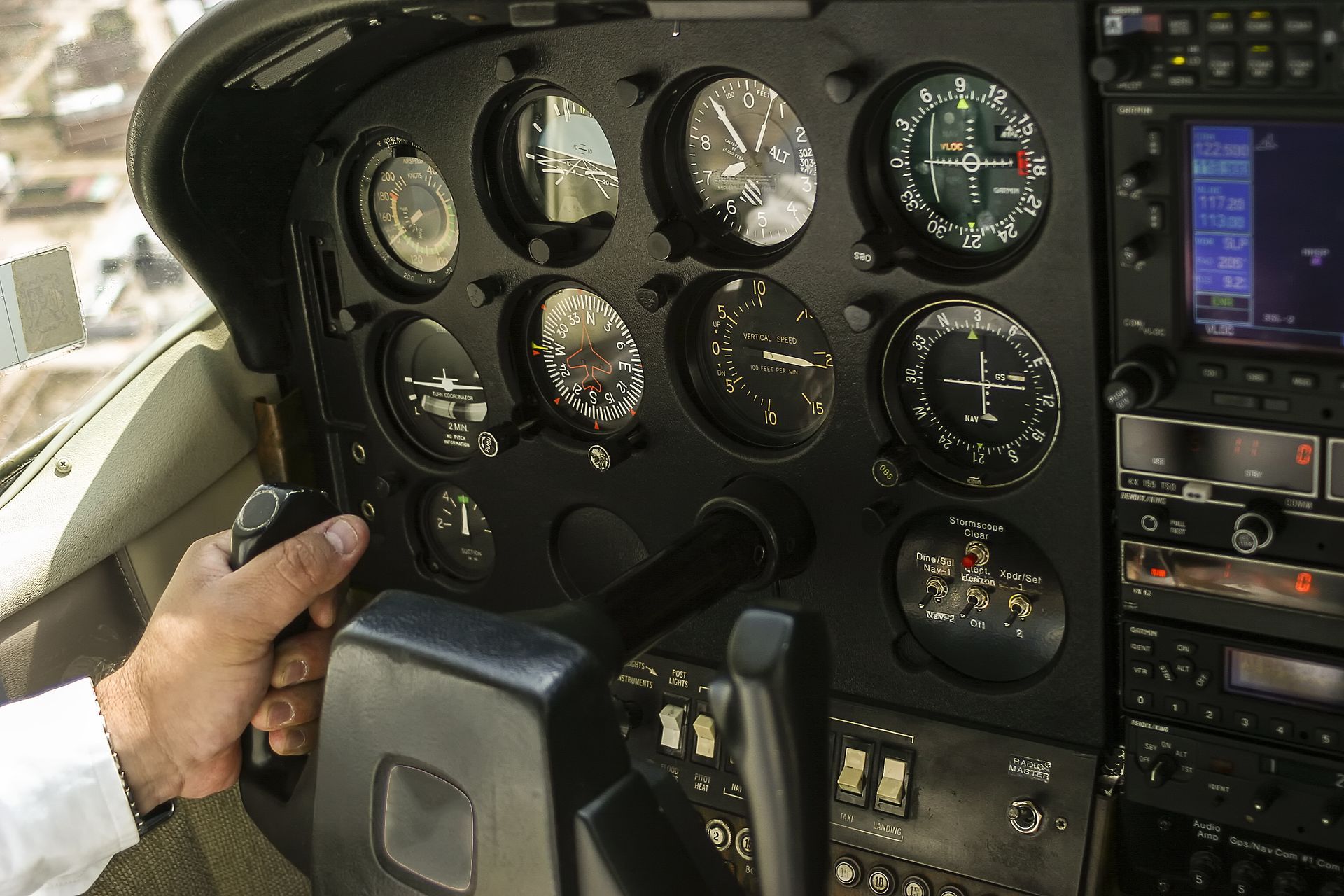 A person is holding a steering wheel in an airplane cockpit