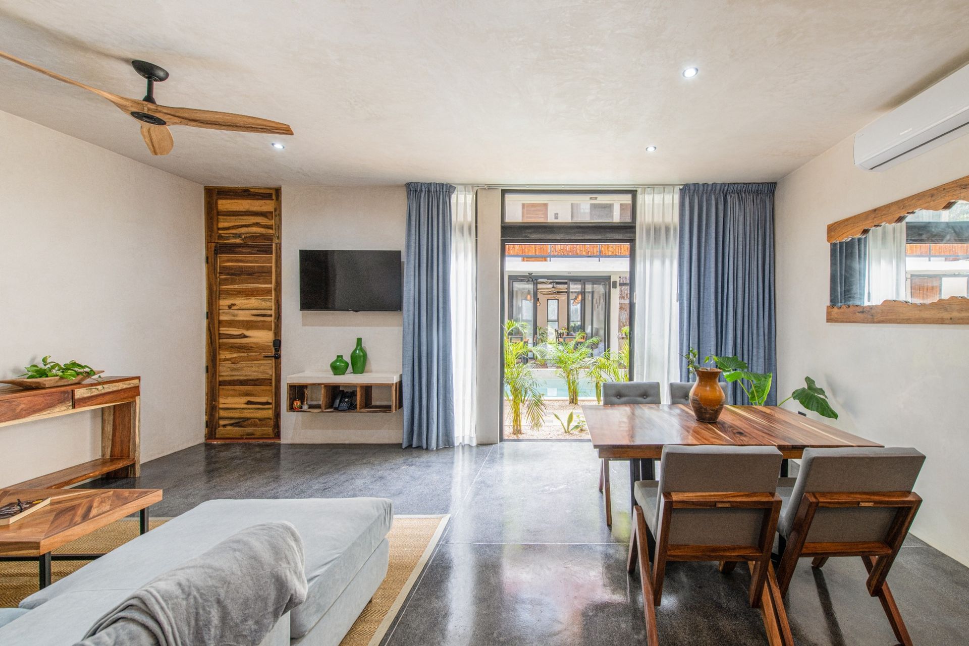 Living room and kitchen area to apartment with pool views