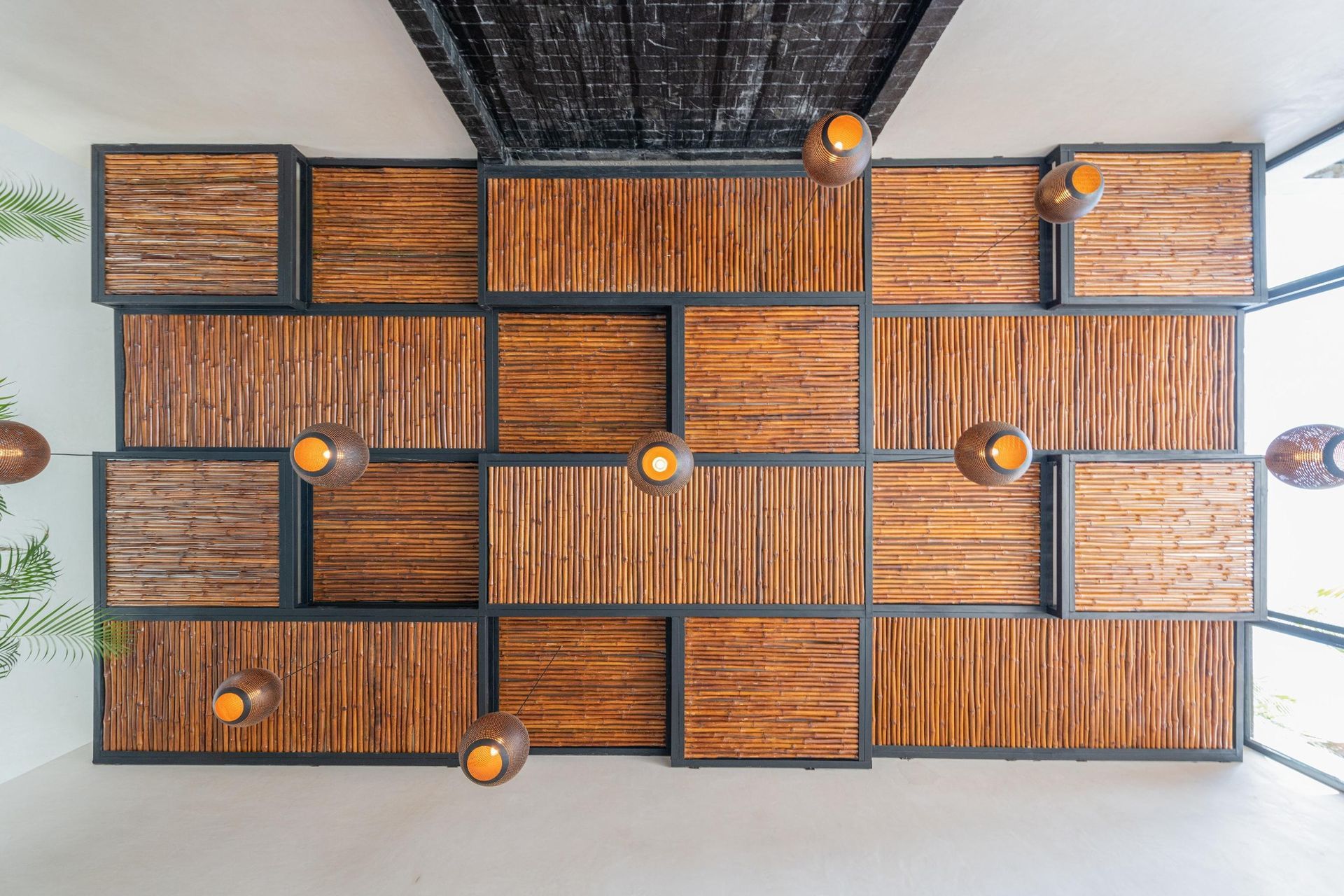 Wood panel wall with metal frames, overhead lighting in a white room.