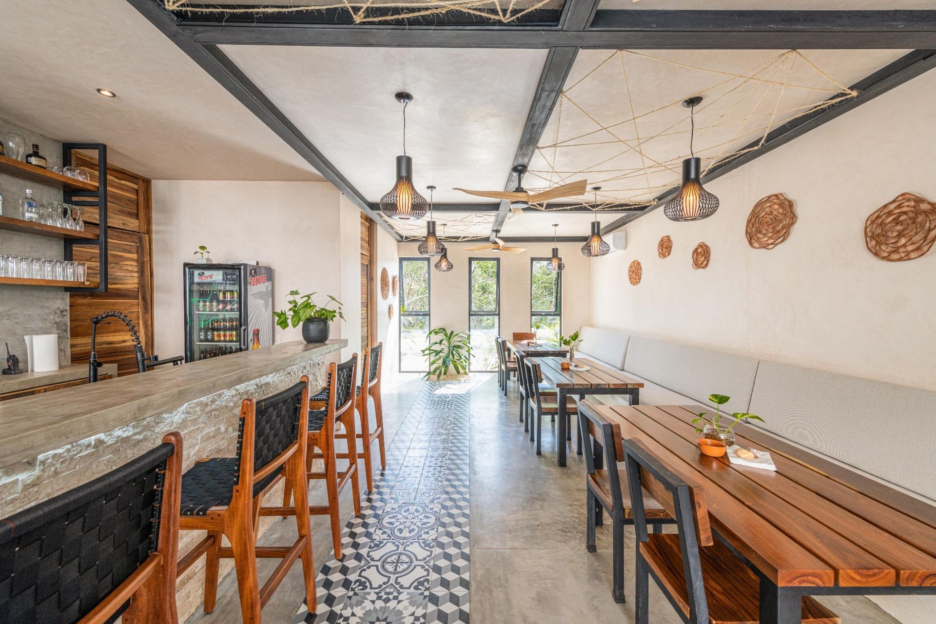 Interior view of a modern restaurant with a bar and dining tables, light and airy.