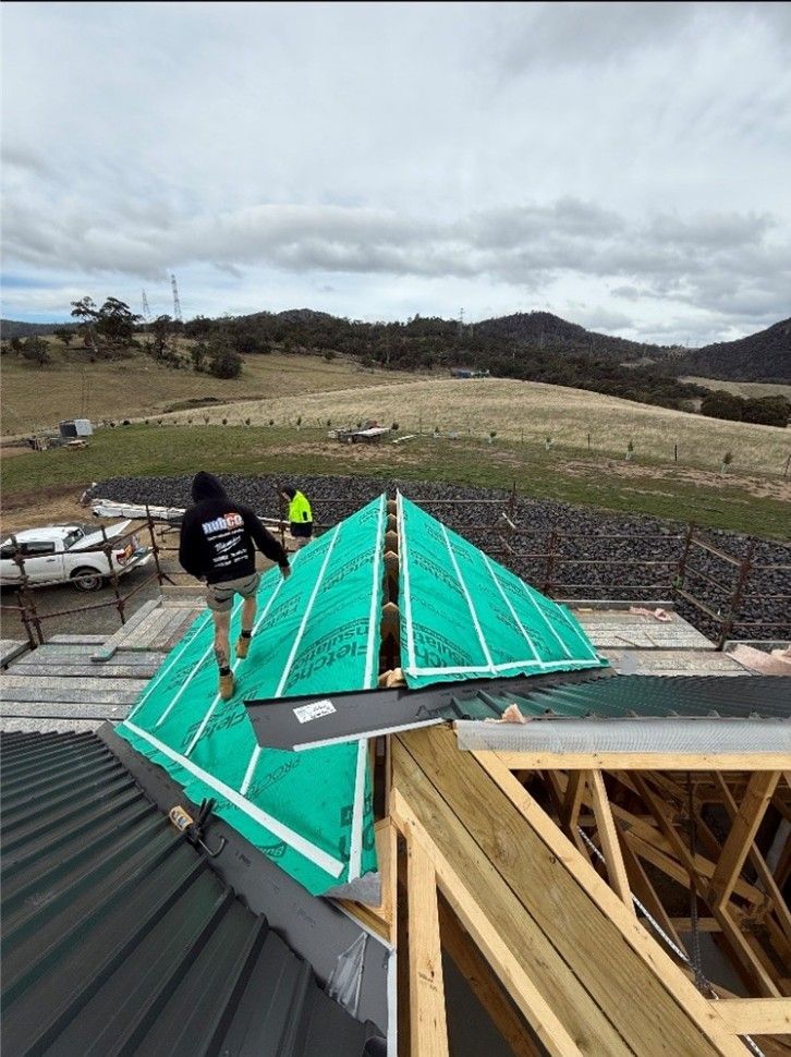 Builder working on roof of new building.