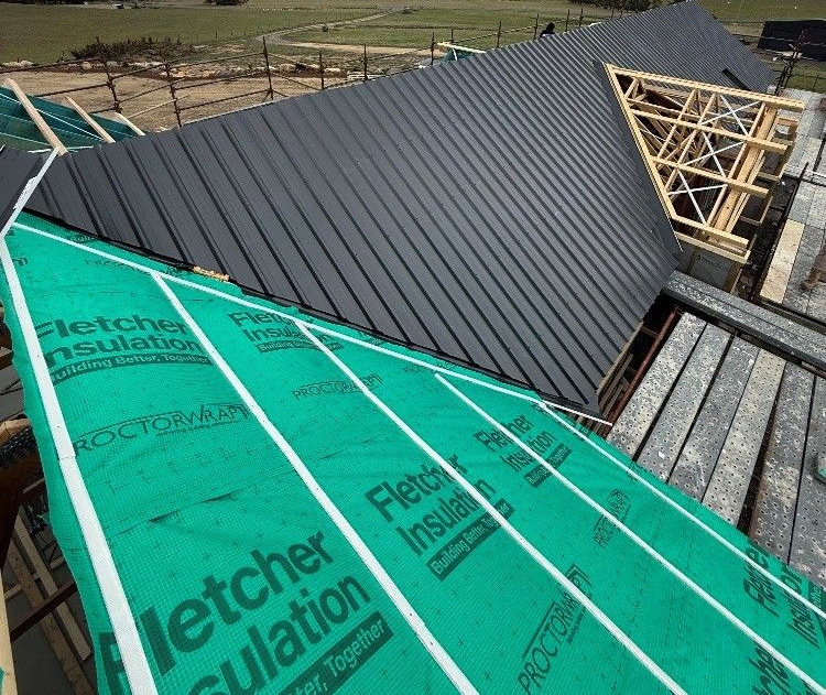 Metal roof installation in process, showcasing roofing services.
