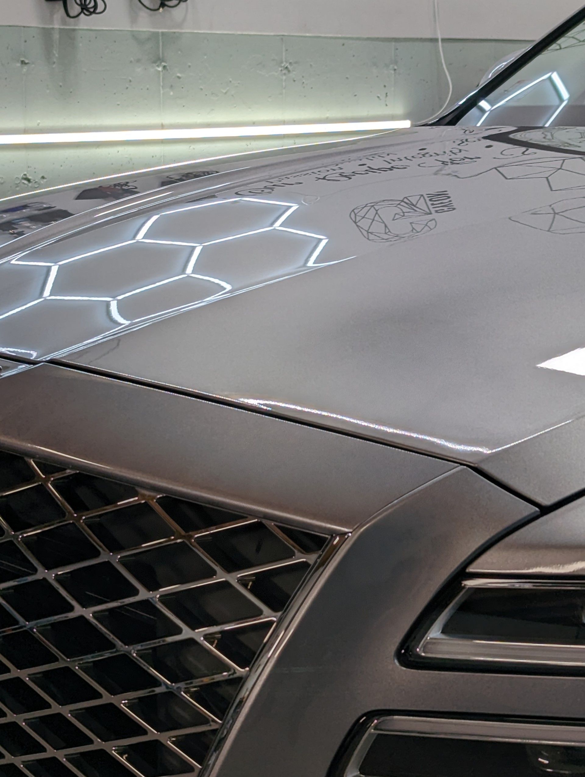 Ceramic Coating - A close up of the hood of a car with a grille .