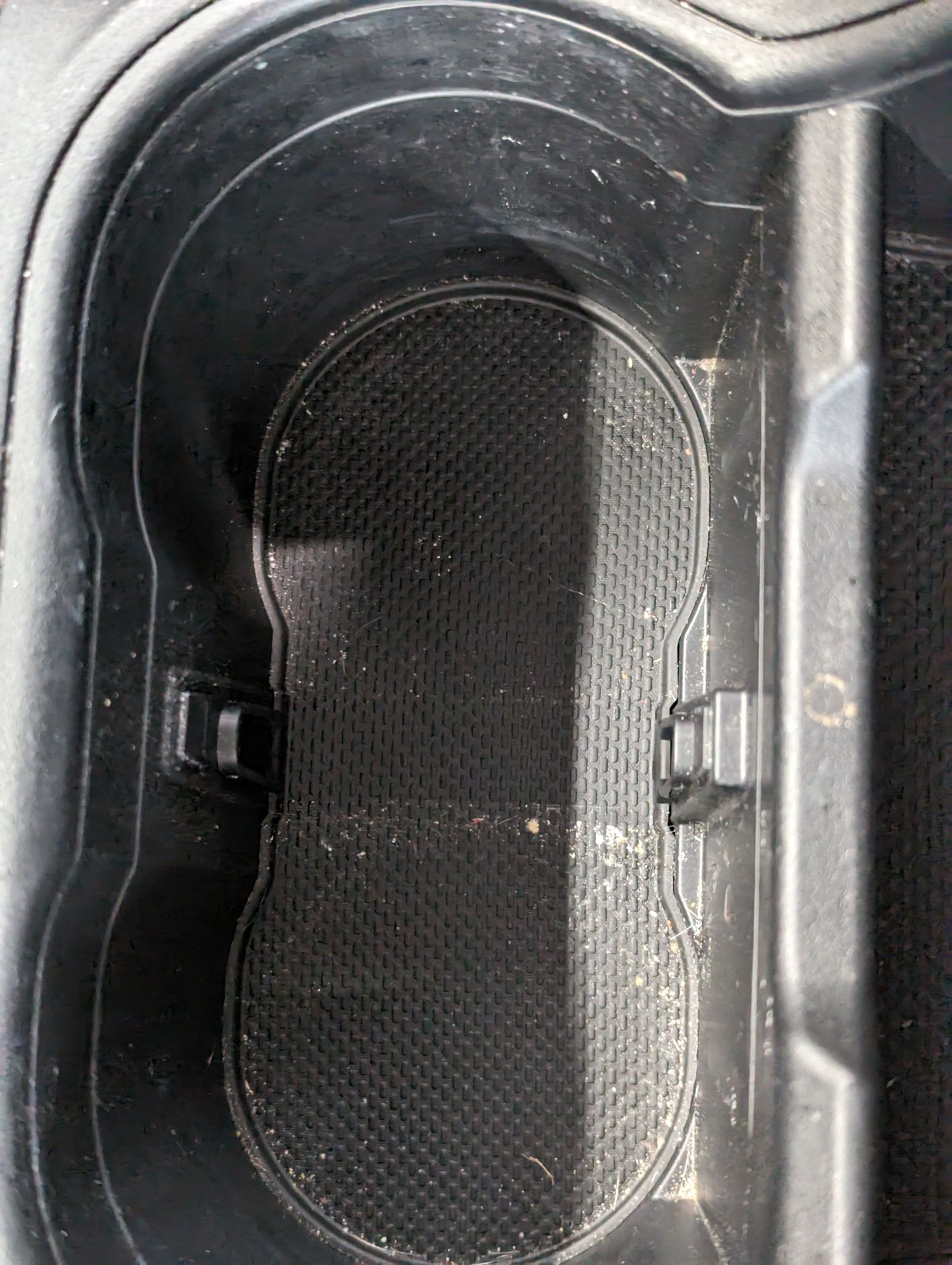 Before Interior Detailing - A close up of a cup holder in a car with two cups in it .
