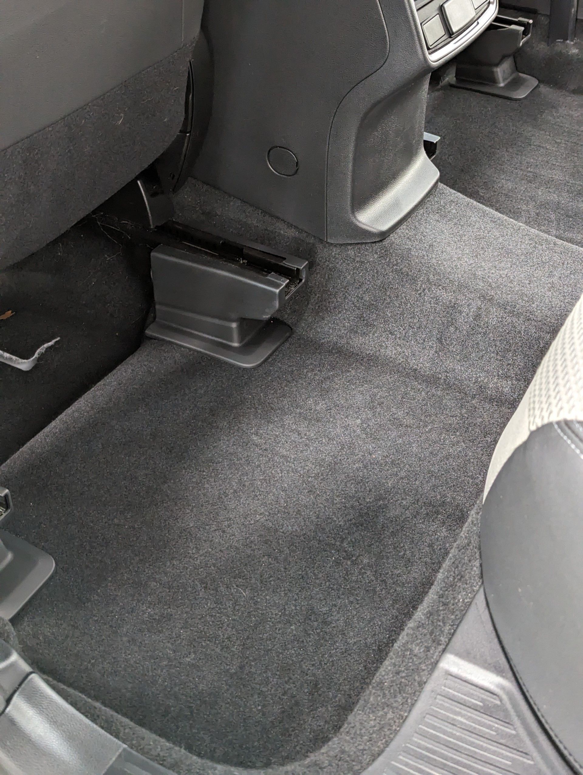 After Interior Detailing - A close up of the floor of a car with a carpeted floor.