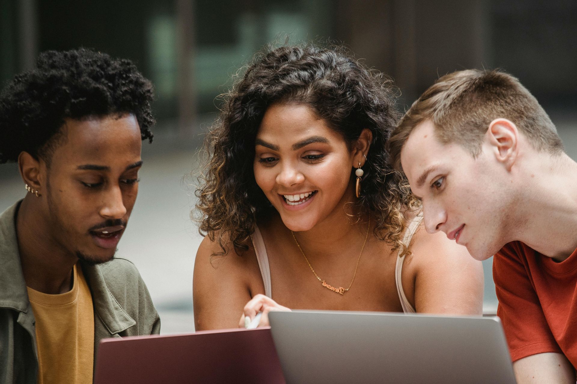A group of young people are looking at a laptop computer, representing the Student Loan Program.