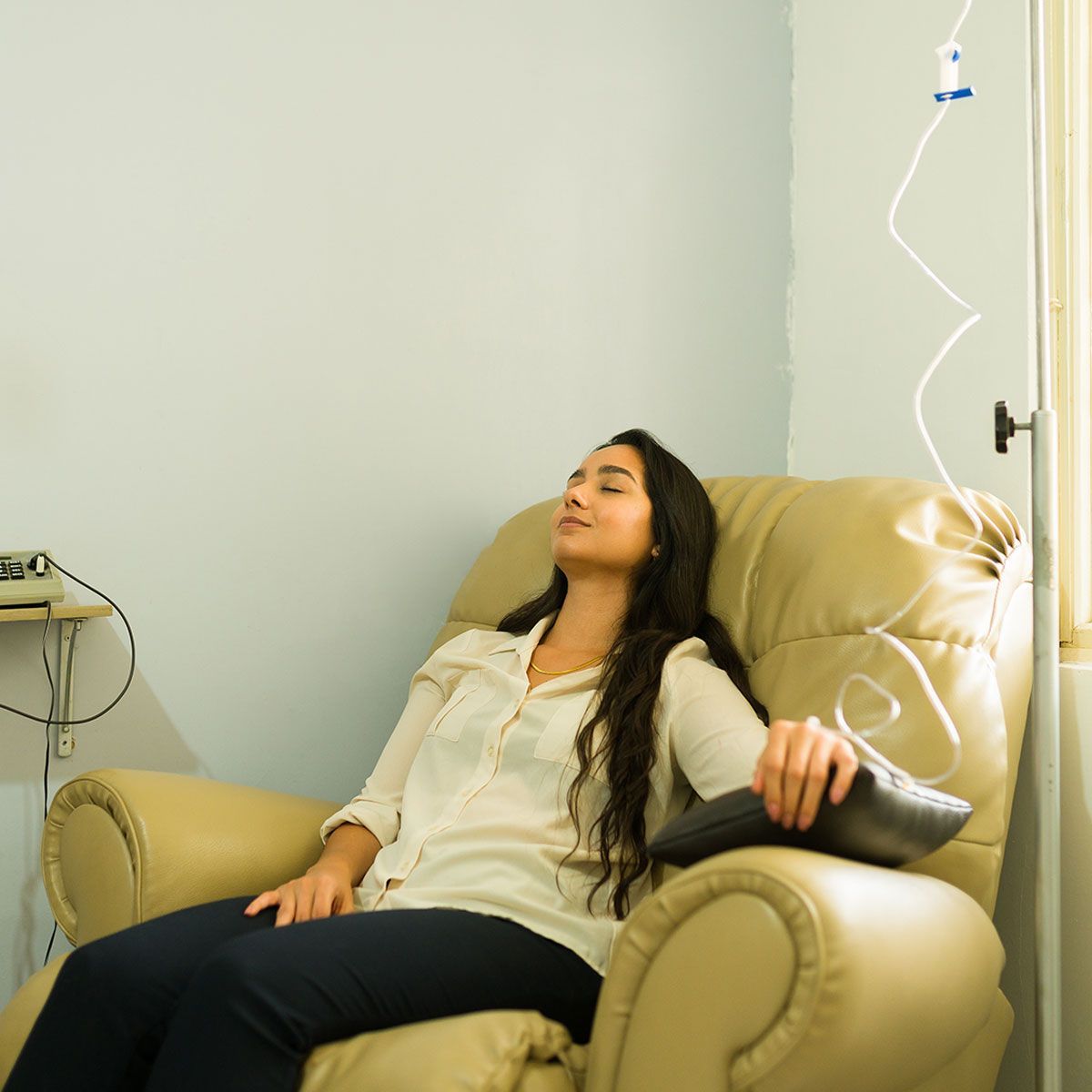 Relaxed woman healing getting a vitamin cocktail with an IV drip treatment