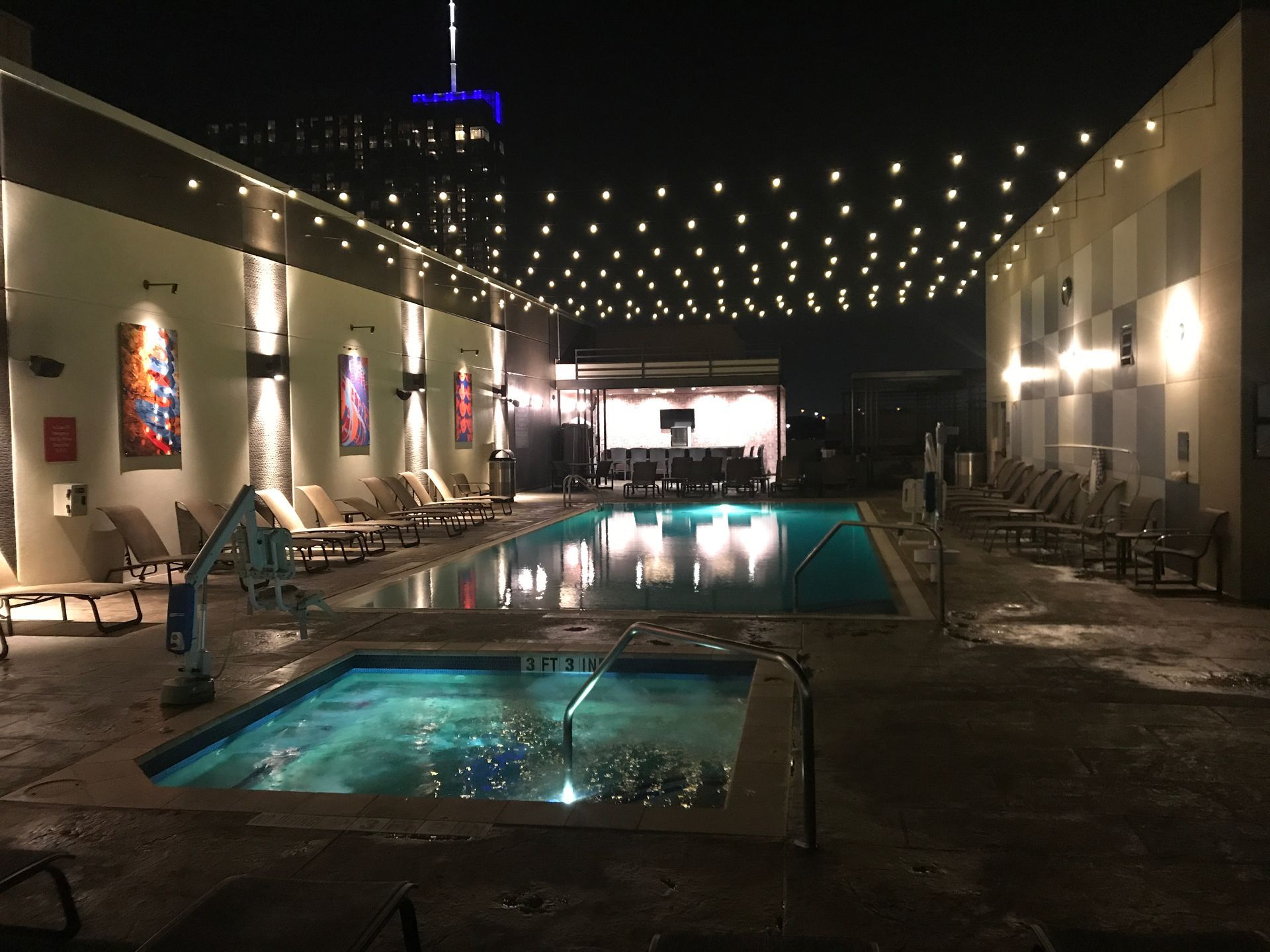 Backyard string lights and pool lighting installation Austin, outdoor lighting design with downtown skyline view