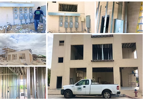 Construction site with electrical work, framing, and a pickup truck parked outside a building.