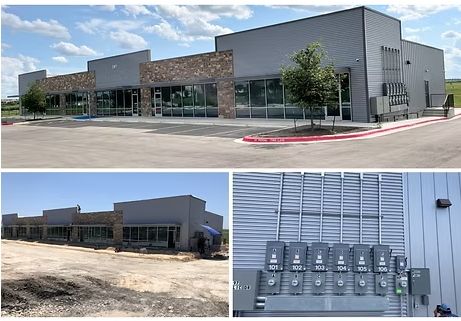 Modern commercial building exterior with large windows, stone accents, and electrical equipment.