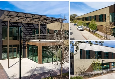 Modern brick building with a metal pergola, glass windows, and parking area.