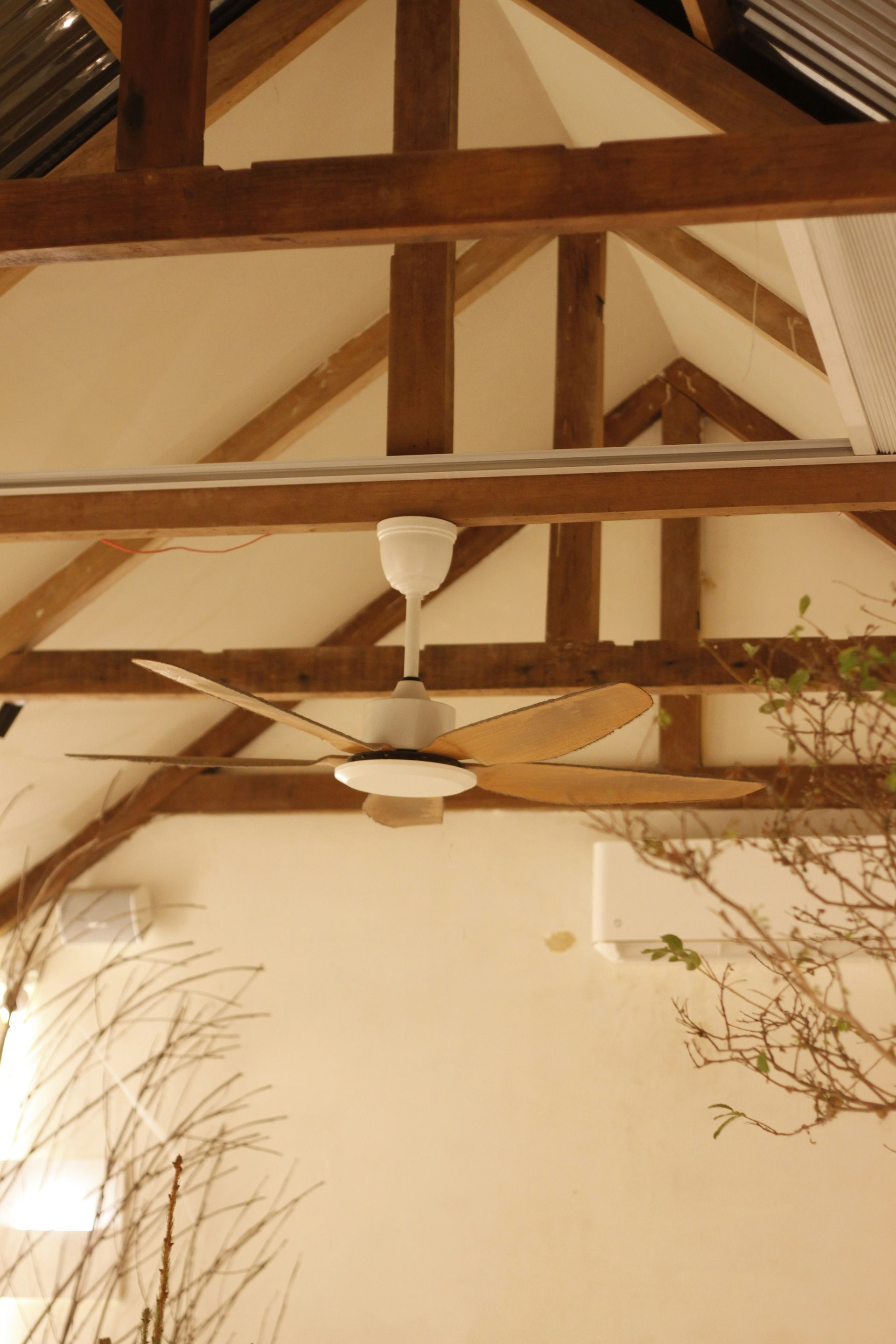 Ceiling fan installation Austin, wood-beam great room with balanced fan and proper downrod