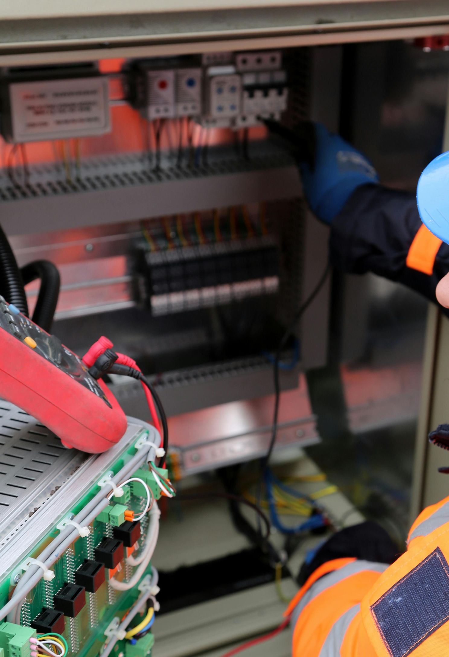 Electrical troubleshooting Austin, licensed electrician testing breaker panel with a multimeter and PPE