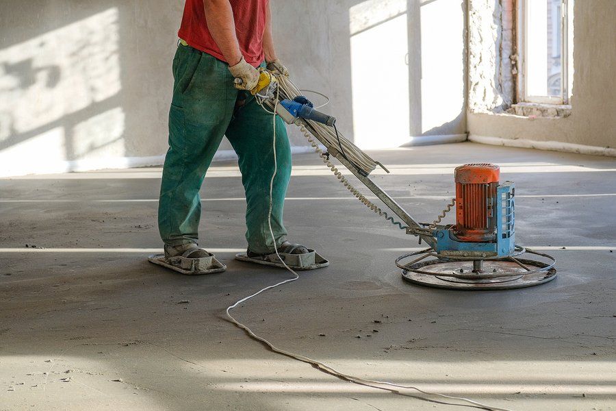 man sanding the floor cement