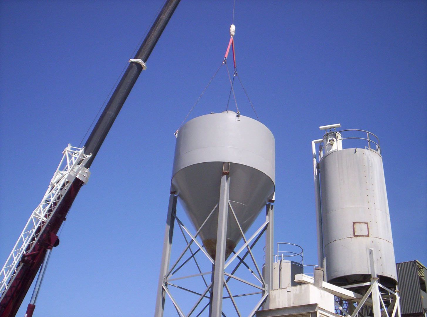 A Crane Is Lifting a Large Silo in The Air — Magnum Steel In Crestwood, NSW