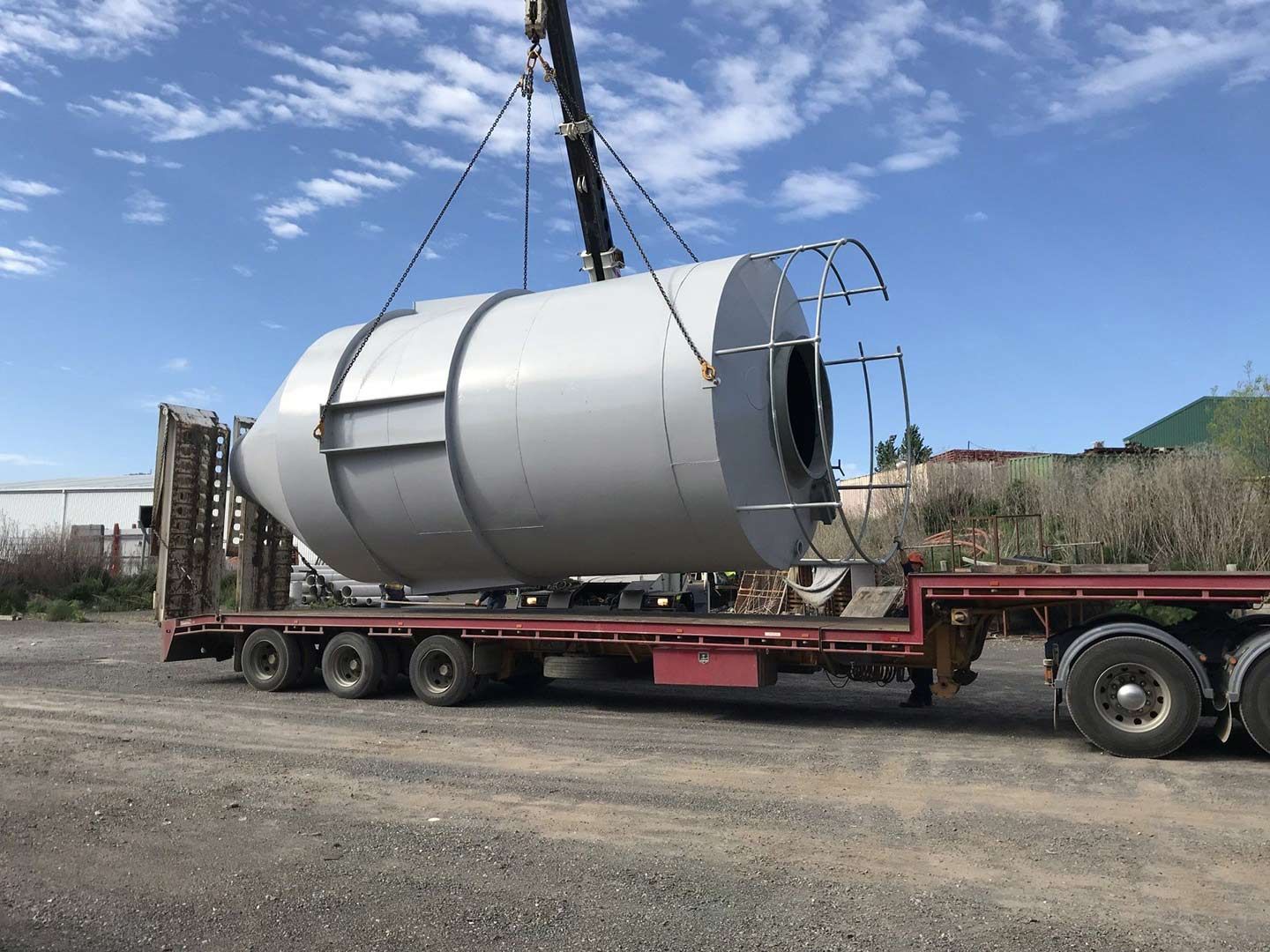 A Large Metal Cylinder Is Being Lifted by A Crane on Top of A Semi Truck — Magnum Steel In Crestwood, NSW