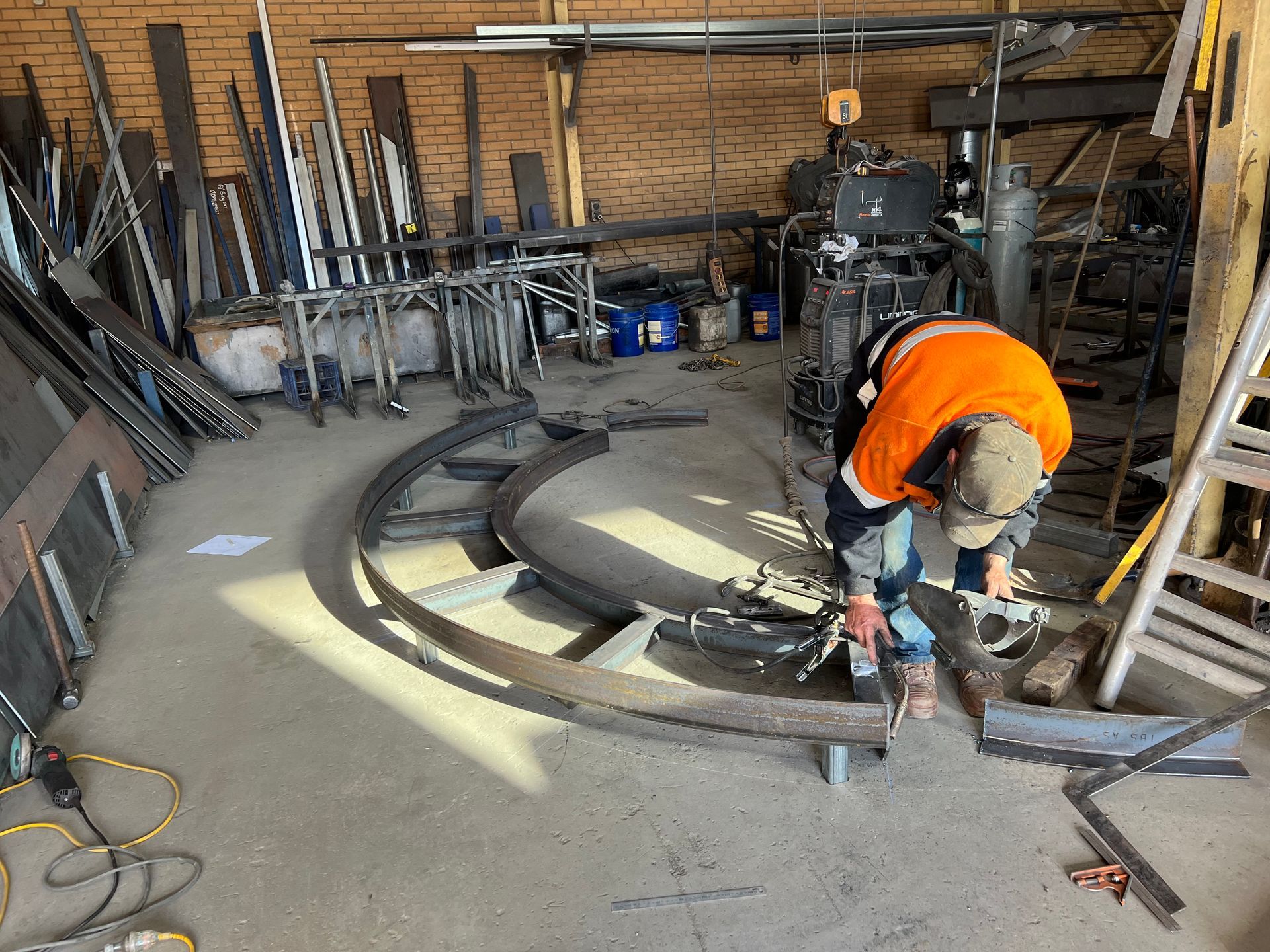 A man is working on a piece of metal in a garage — Magnum Steel In Crestwood, NSW