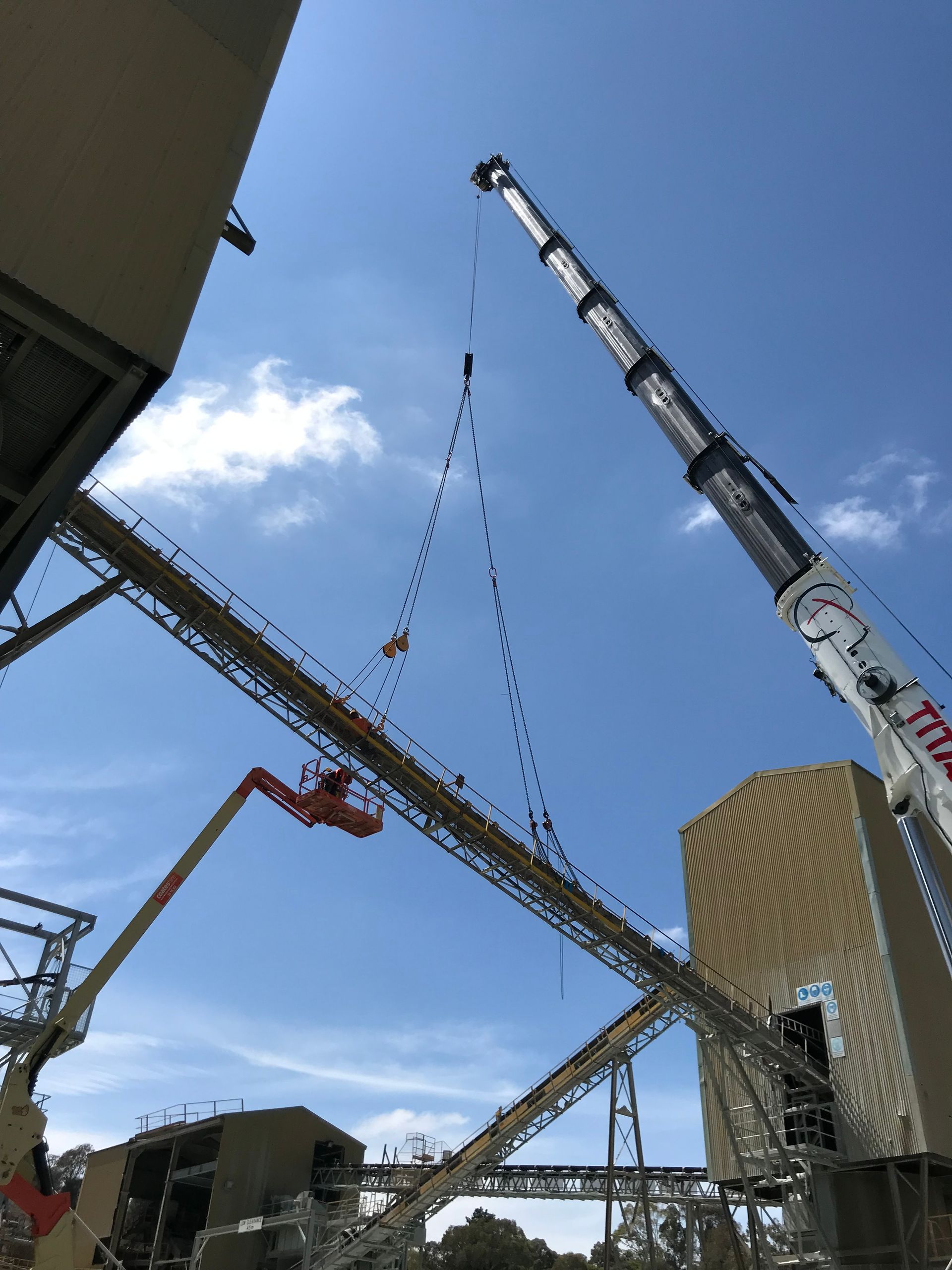 A crane is lifting a conveyor belt in a factory — Magnum Steel In Crestwood, NSW