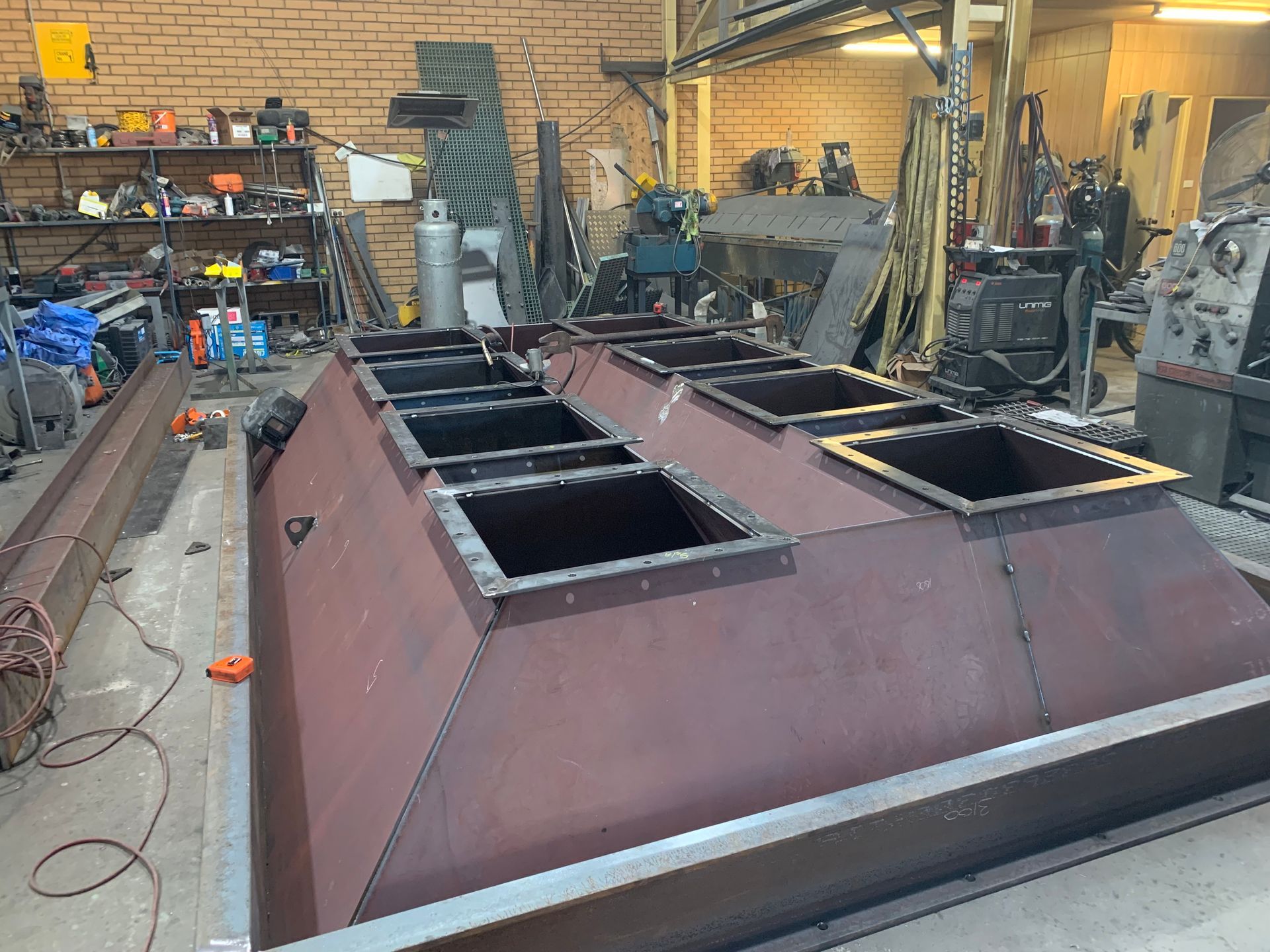 A large metal structure is being built in a factory — Magnum Steel In Crestwood, NSW