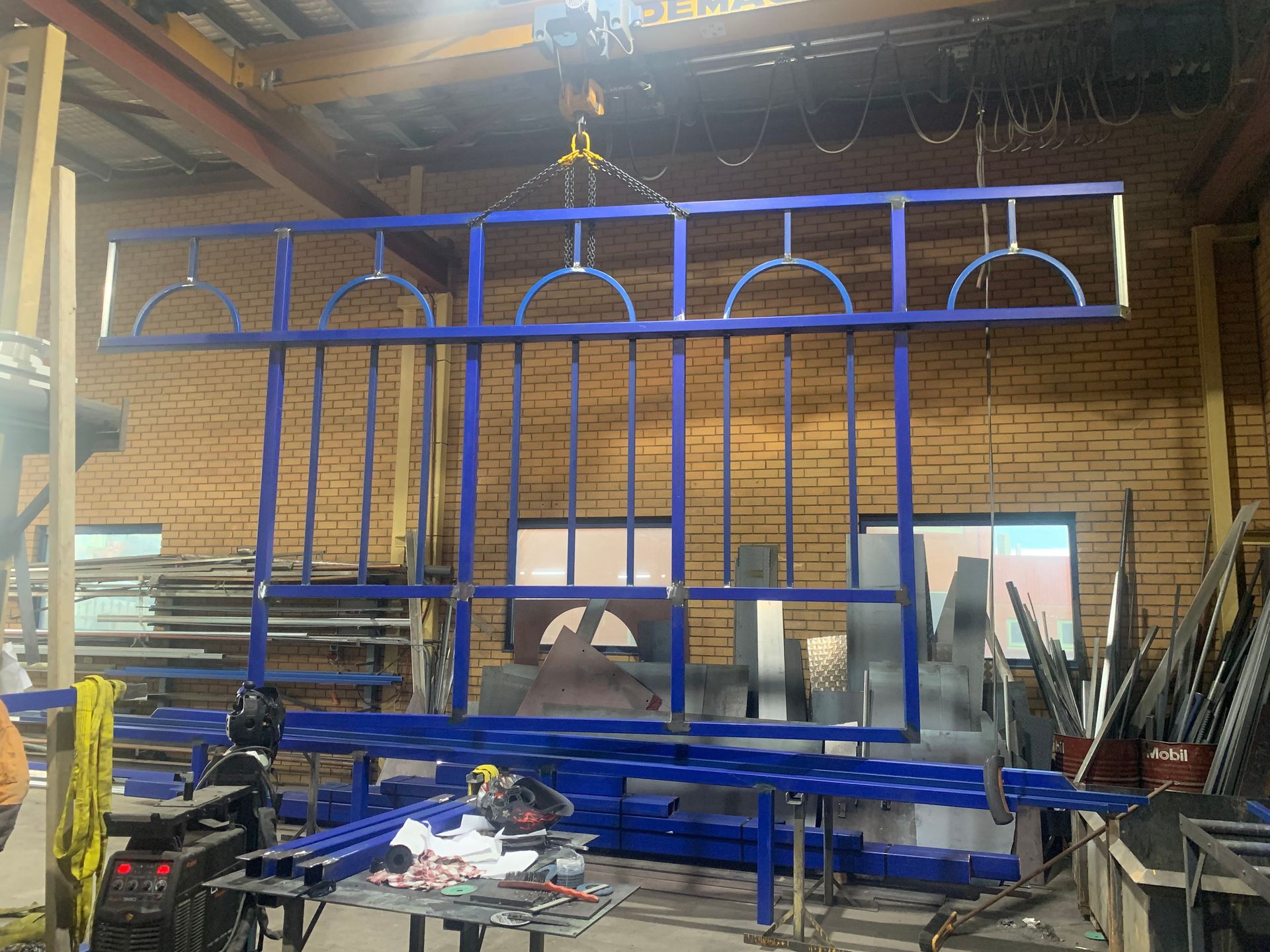 A blue metal fence is being built in a factory — Magnum Steel In Crestwood, NSW