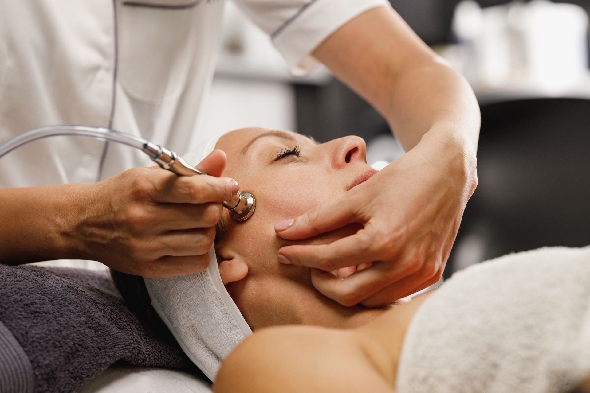 A woman is getting a facial treatment at a beauty salon.