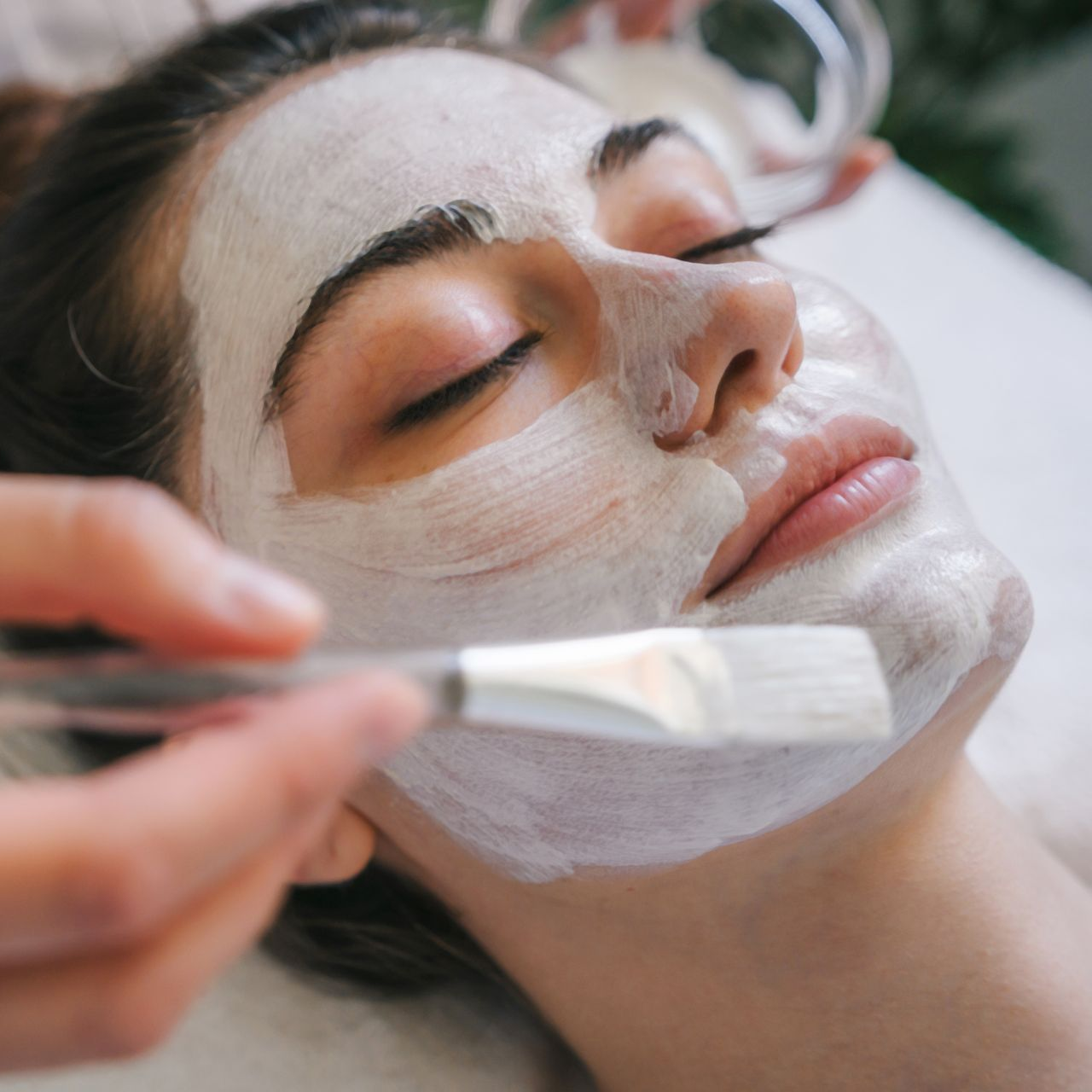 A woman is getting a facial treatment at a spa.