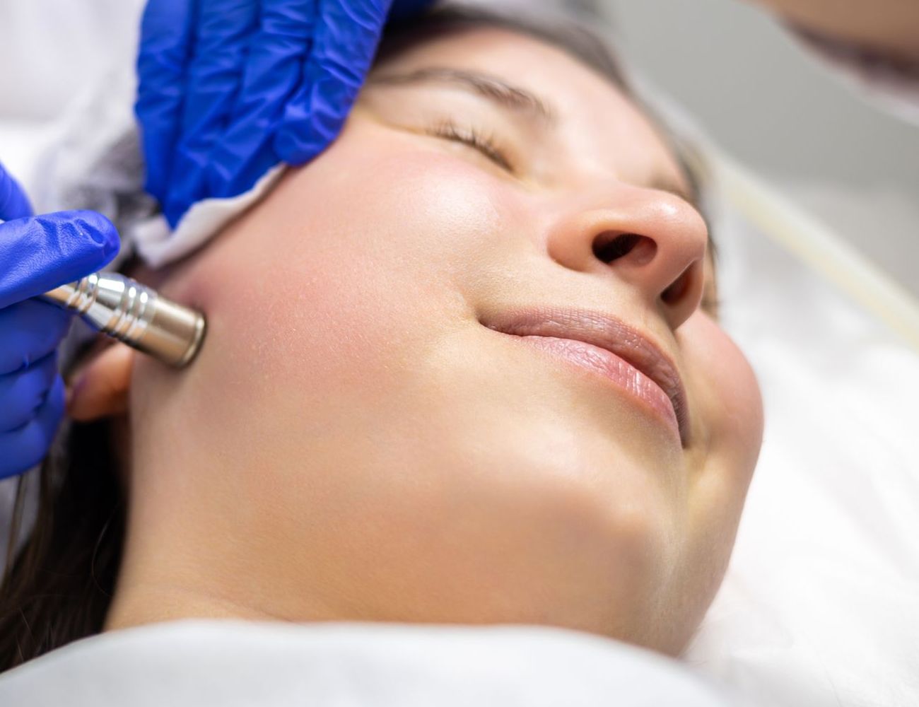 A woman is getting a facial treatment at a beauty salon.