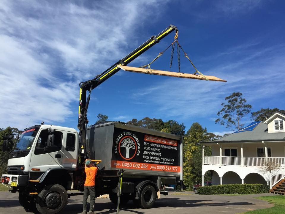 A Man Is Standing Next To A Truck With A Crane Attached To It — All Area Tree Service Pty Ltd In Fountaindale, NSW