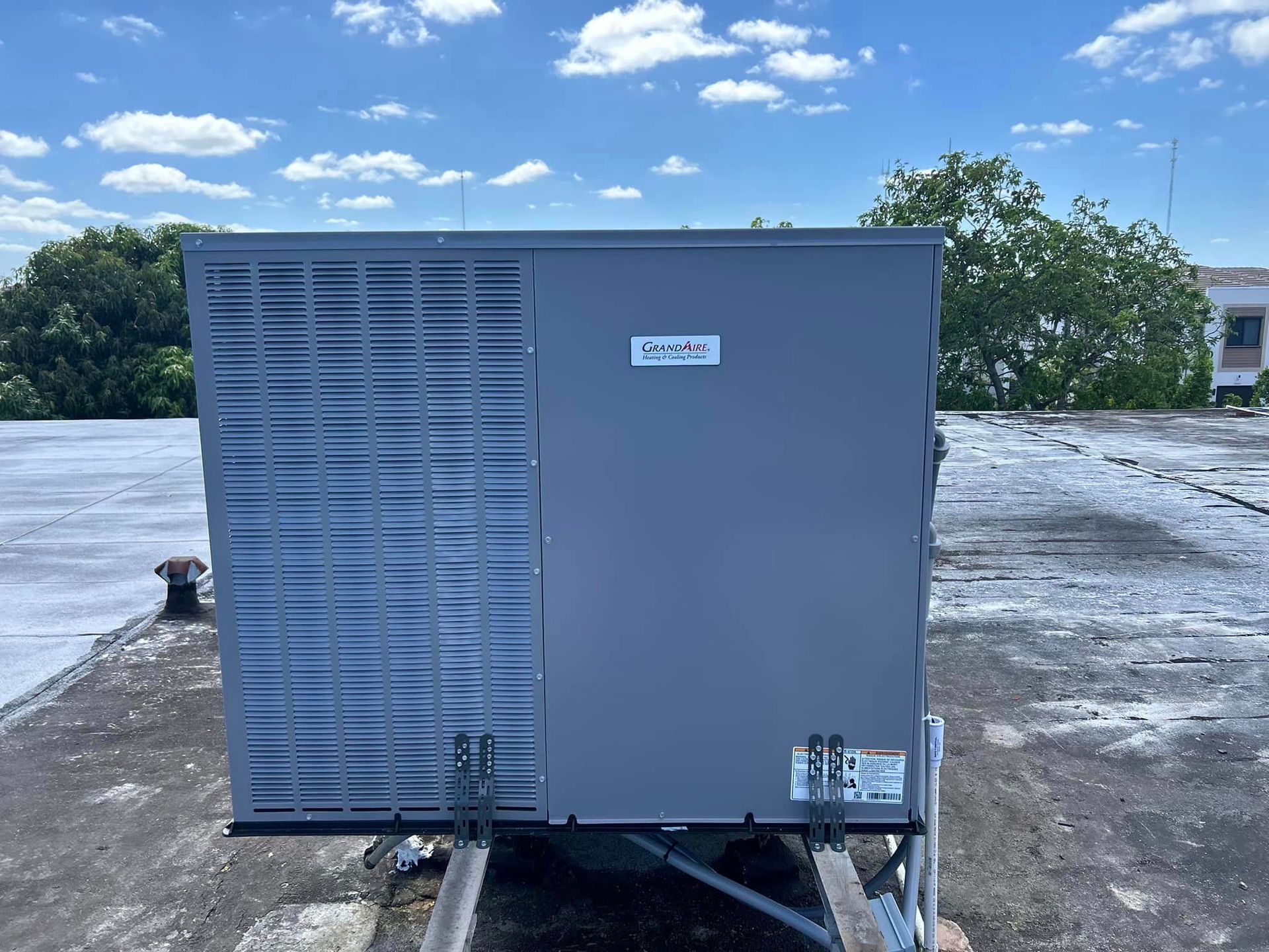 A large air conditioner is sitting on top of a roof.