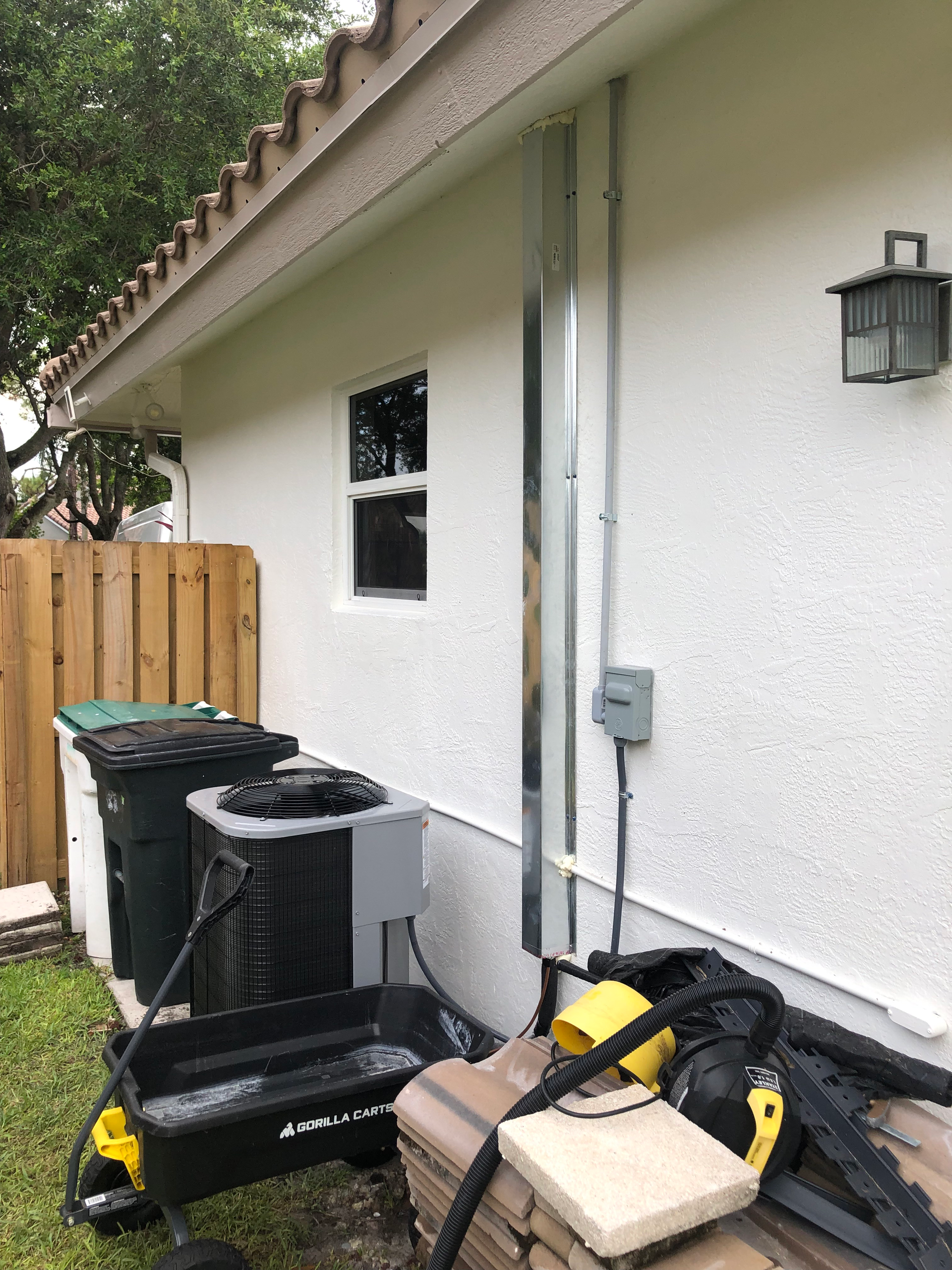 A house with a lot of trash cans and a vacuum cleaner on the side of it.