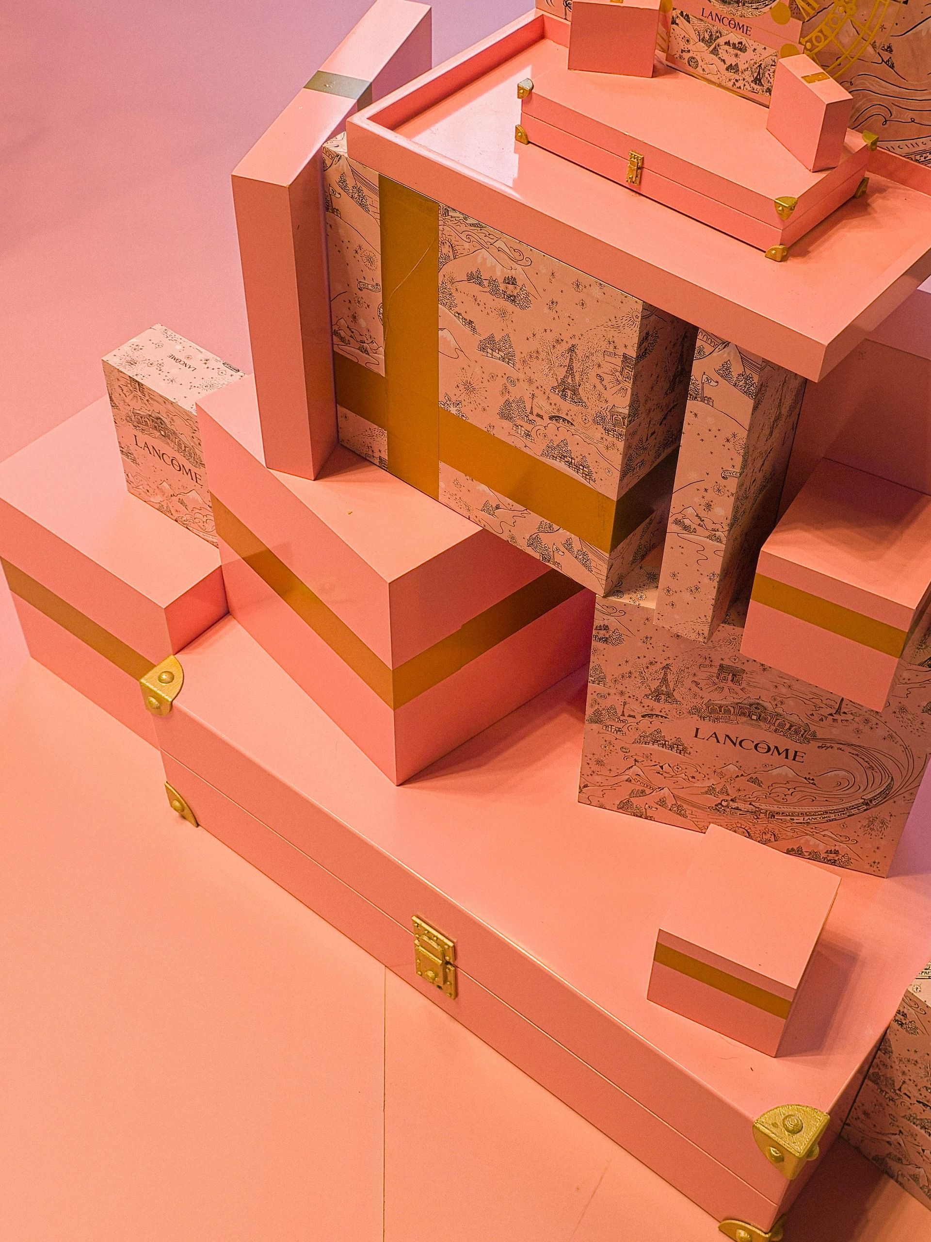 Escultura abstracta de bloques rosas y moteados con acentos dorados.