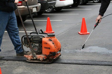 Repairing Asphalt — Worker Paving the Road in Charlotte, NC