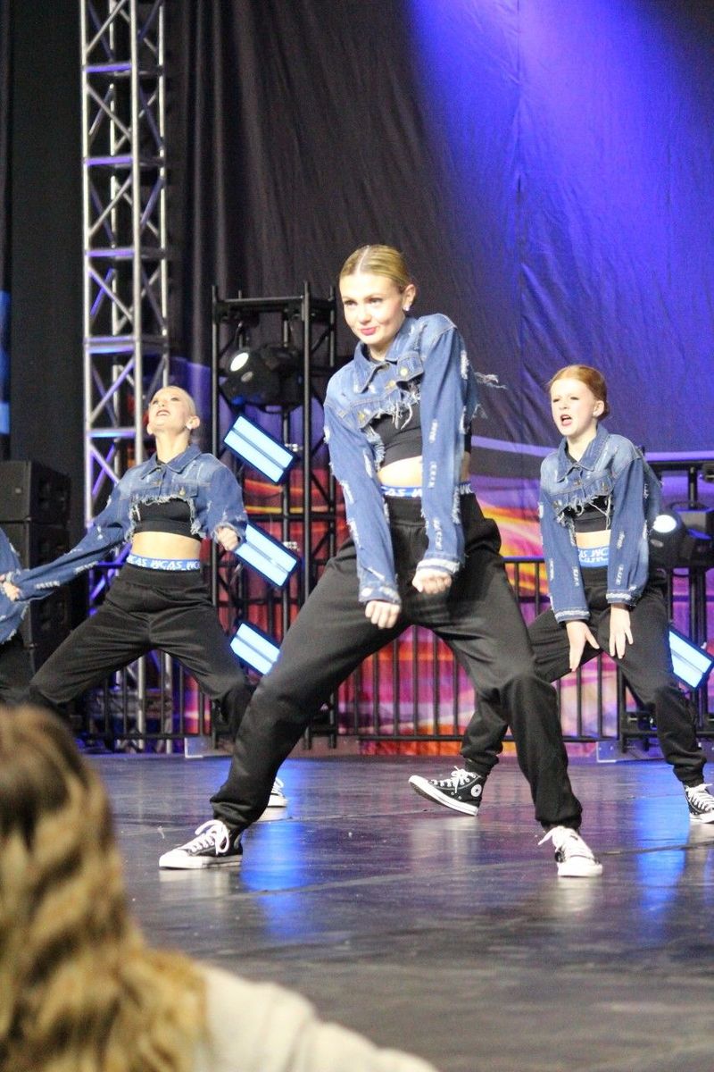 A group of young girls are dancing on a stage.