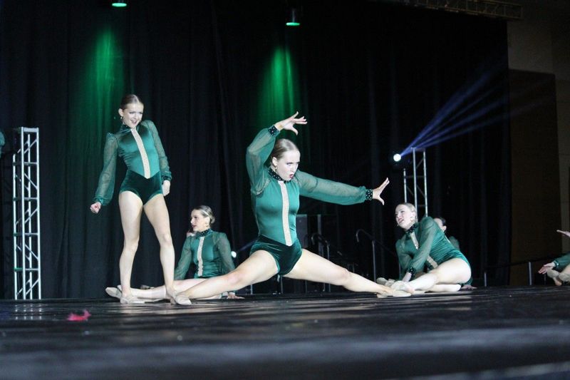 A group of young women are performing a dance on a stage.