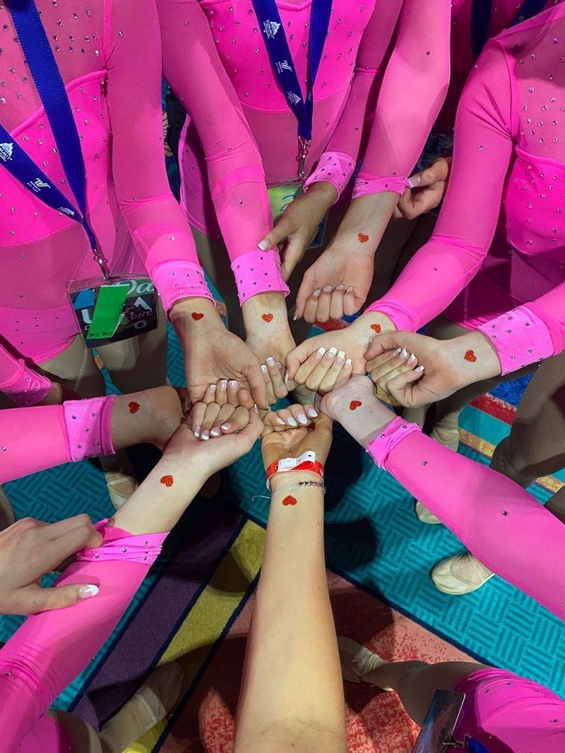 A group of girls are putting their hands together in a circle.