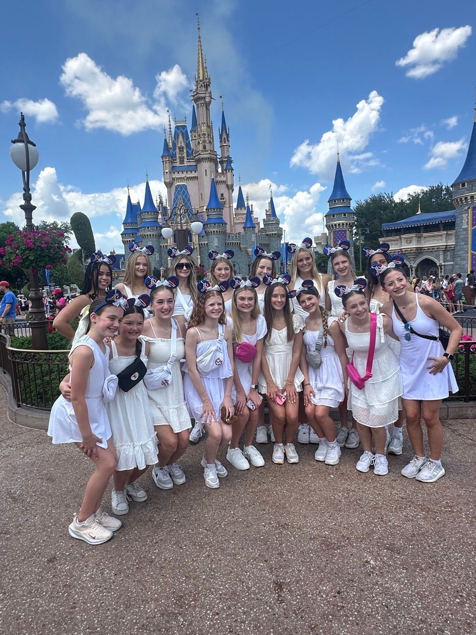 A group of girls are posing for a picture in front of a castle.