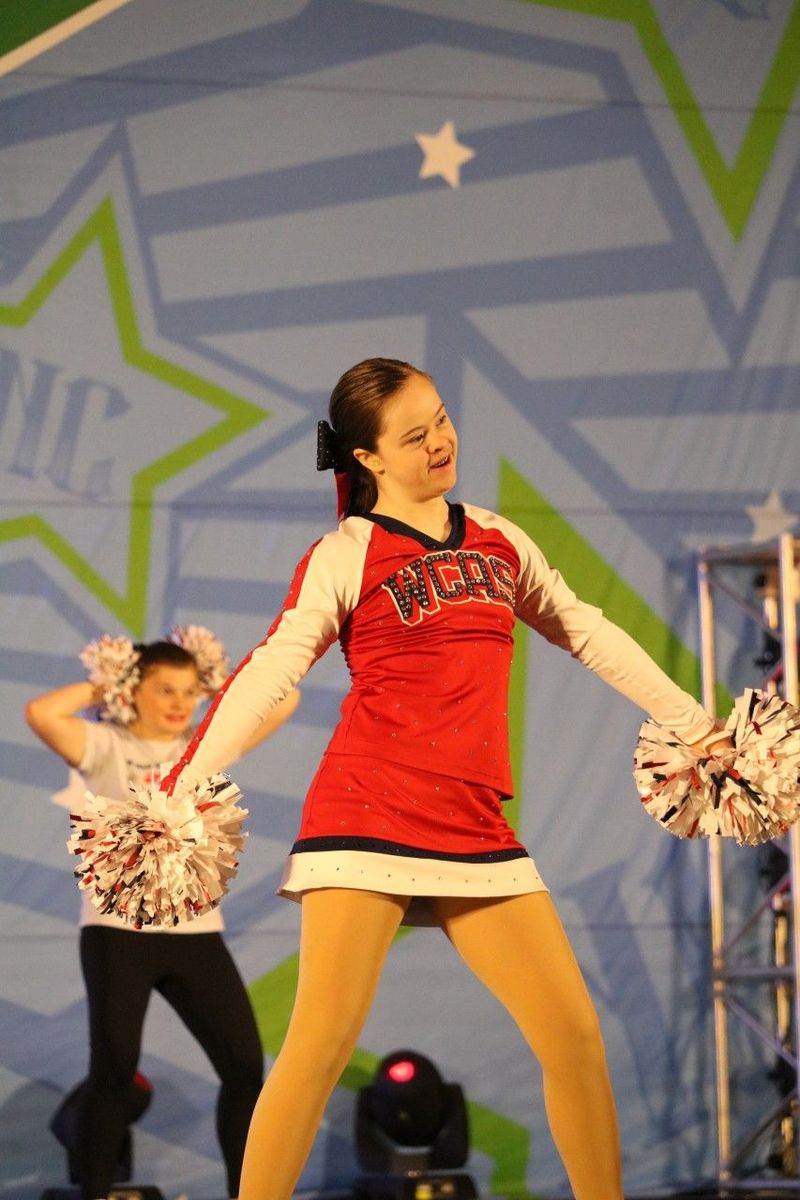A cheerleader in a red jersey with the word west on it