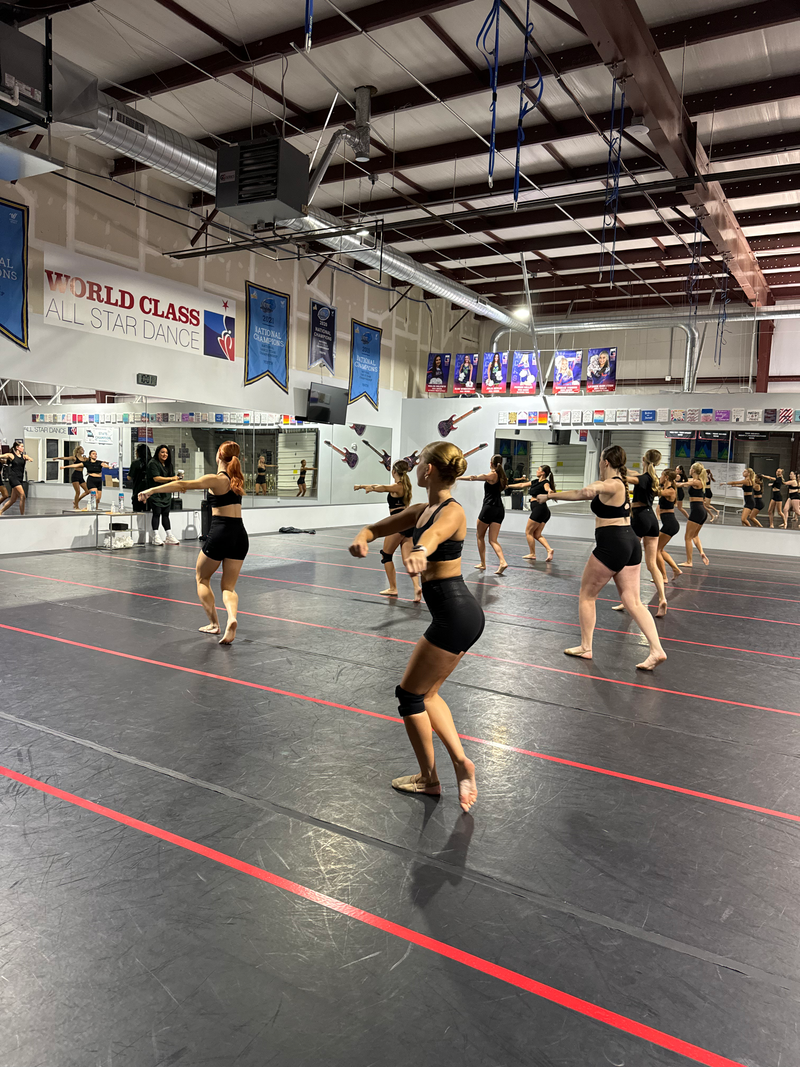 A group of women are dancing in a gym.