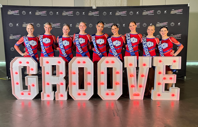 A group of girls are standing in front of a sign that says groove