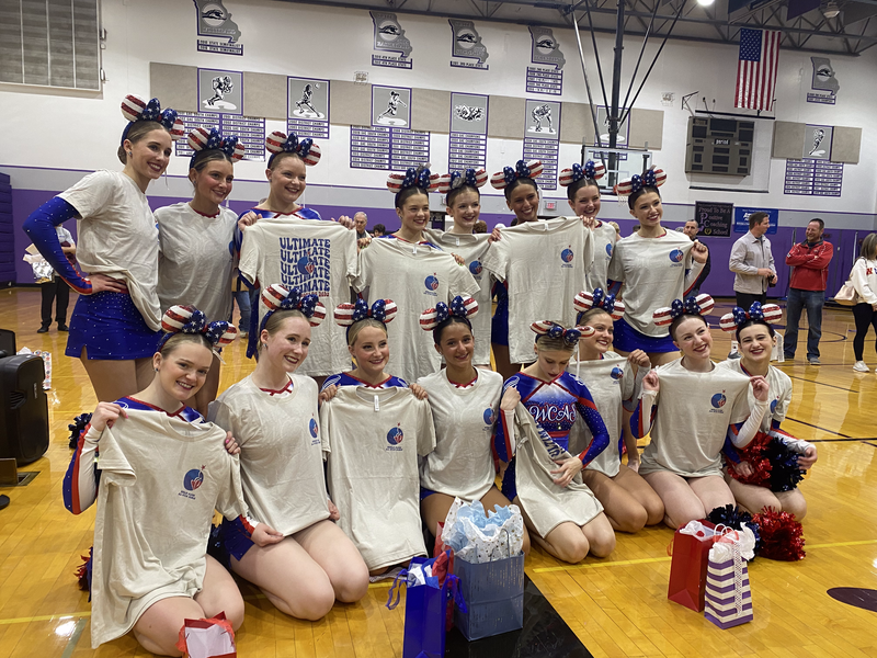 A group of cheerleaders posing for a picture in a gym