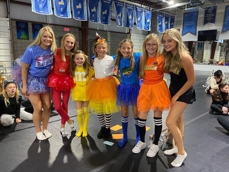 A group of young girls are posing for a picture in a gym.