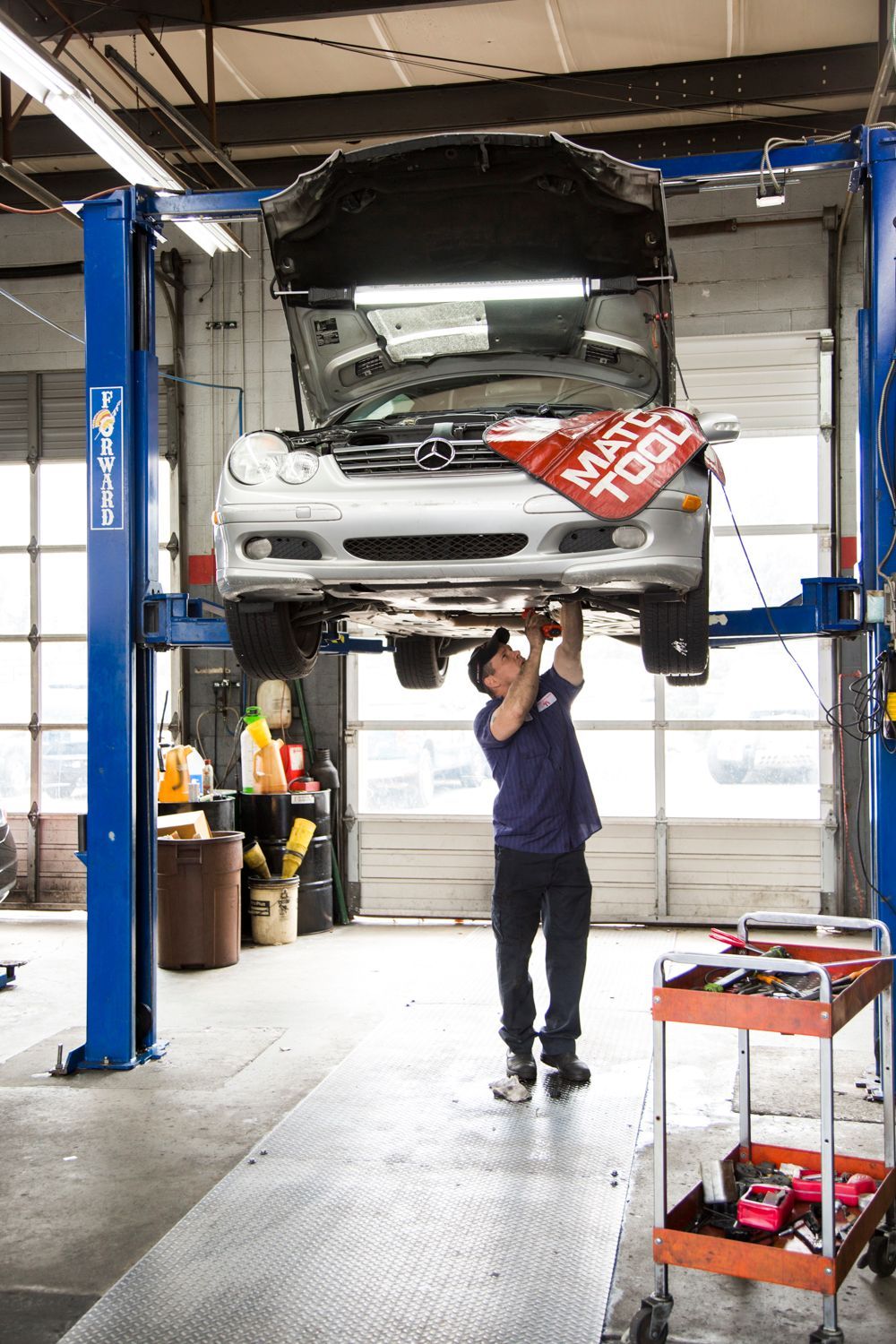 Mechanic working on a car lifted on a hydraulic rack in a garage  | Premier Auto Repair