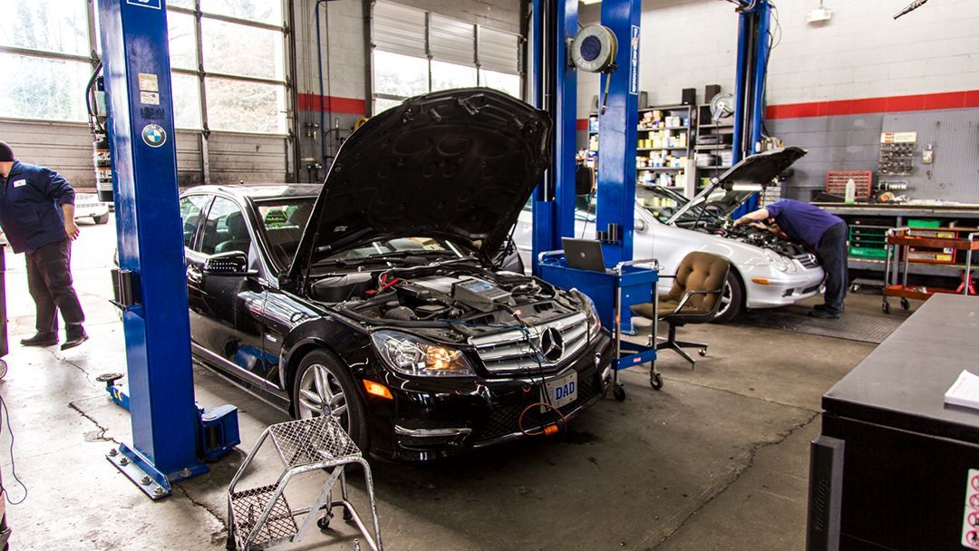 Two cars with open hoods in an auto repair shop  | Premier Auto Repair
