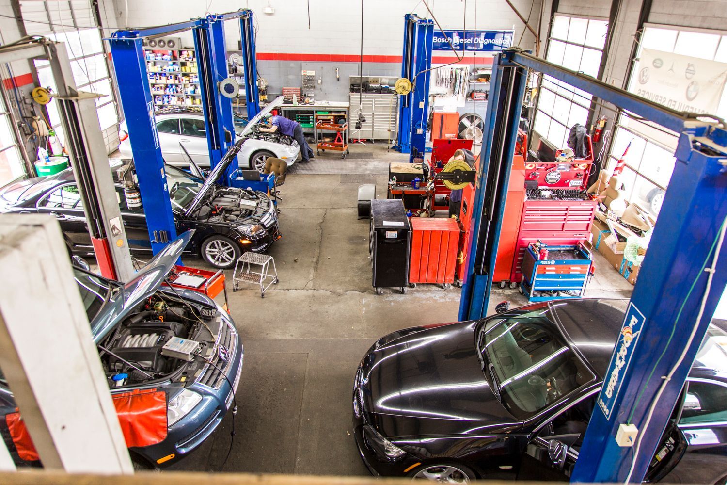 An auto repair shop with vehicles on lifts, mechanics working, and tools | Premier Auto Repair
